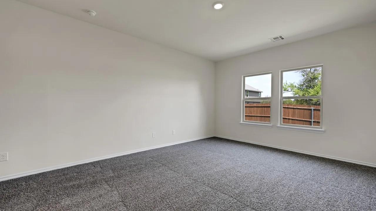 Recessed ceiling light, two windows with white trim, wall-to-wall carpeting, and light-toned wall finishes