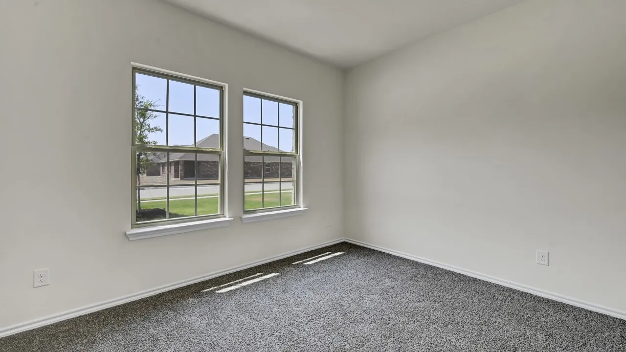 Double windows with grid pattern, white trim, grey carpeting, and light-toned walls