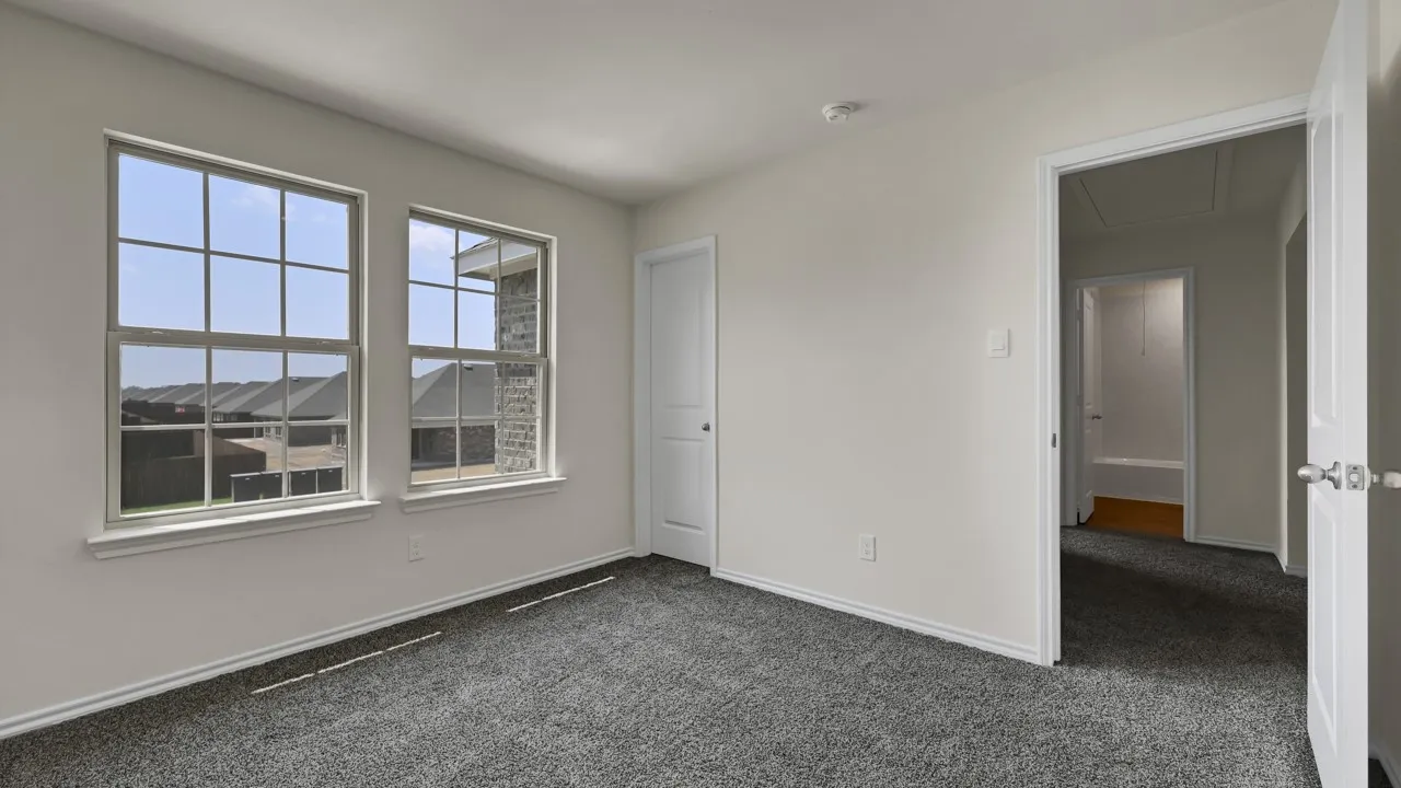 Neutral wall finishes, two paneled doors, and gray carpet flooring