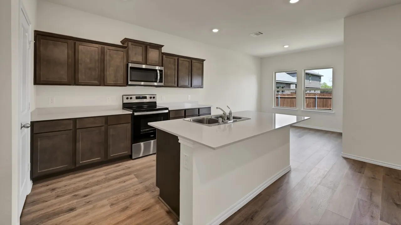 Kitchen featuring wood-finish flooring, dark wood cabinetry, a stainless steel range, a stainless steel microwave, and white countertops