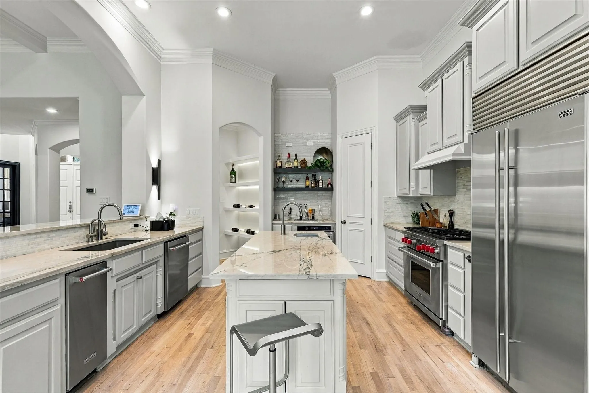 Gourmet kitchen featuring a central island, recessed lighting, stainless steel appliances, light wood-finish flooring, and light-toned countertops