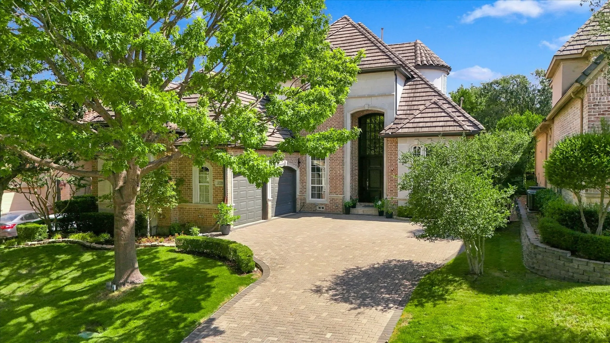 Brick exterior with stone accents and a paver driveway