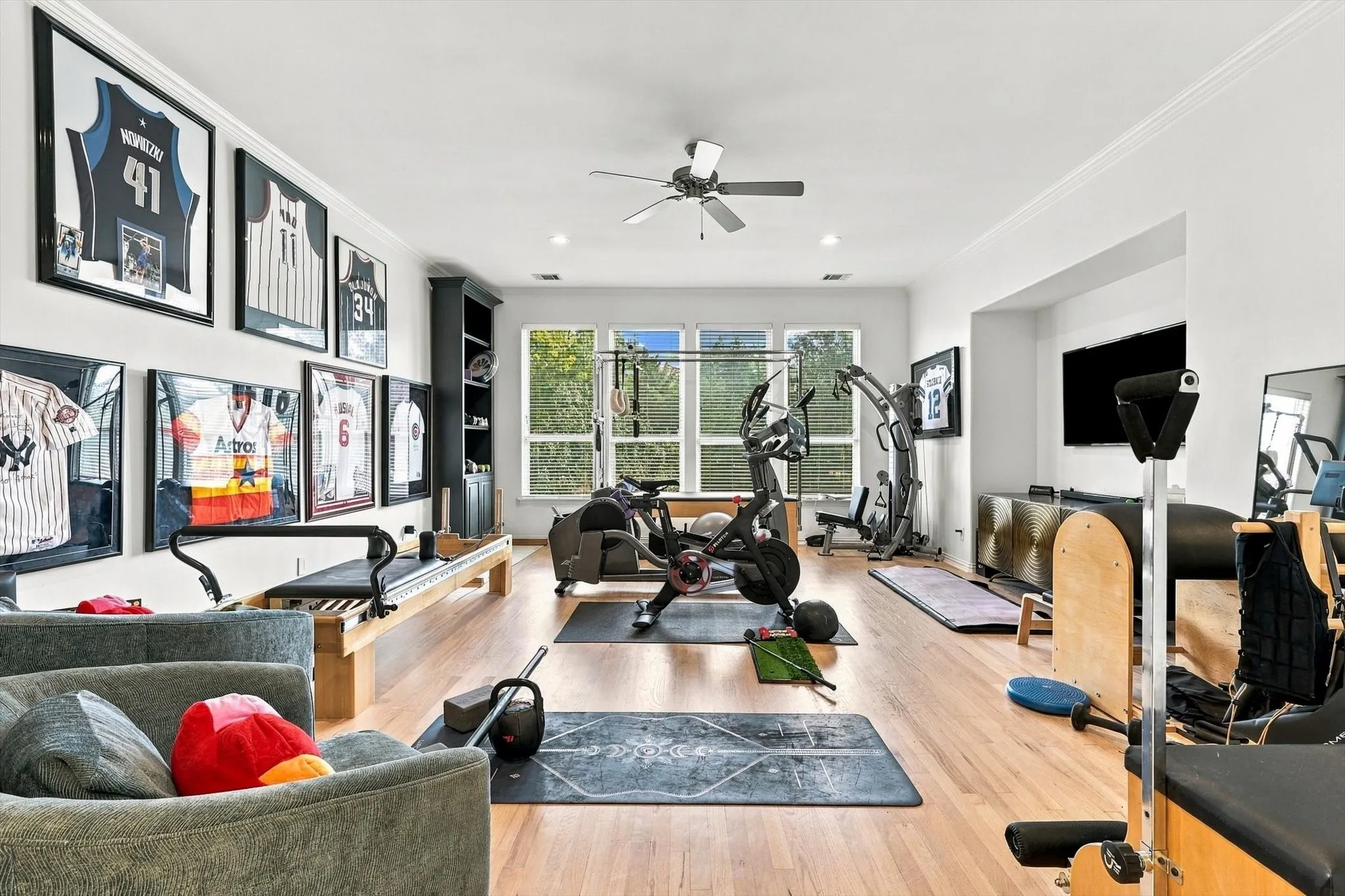 Hardwood flooring, recessed lighting, ceiling fan, built-in shelving, and large windows