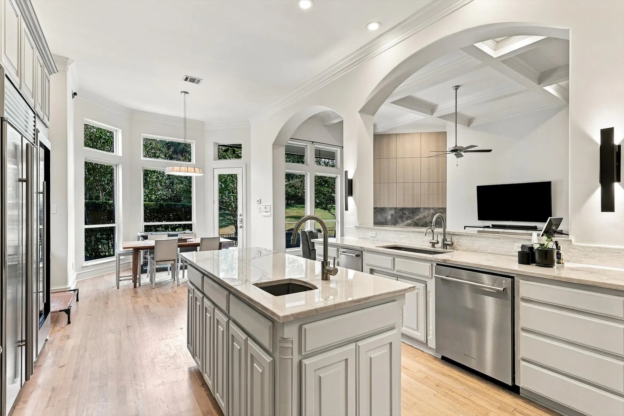 Gourmet kitchen featuring a large central island, light wood-finish flooring, recessed lighting, stainless steel appliances, and extensive cabinetry