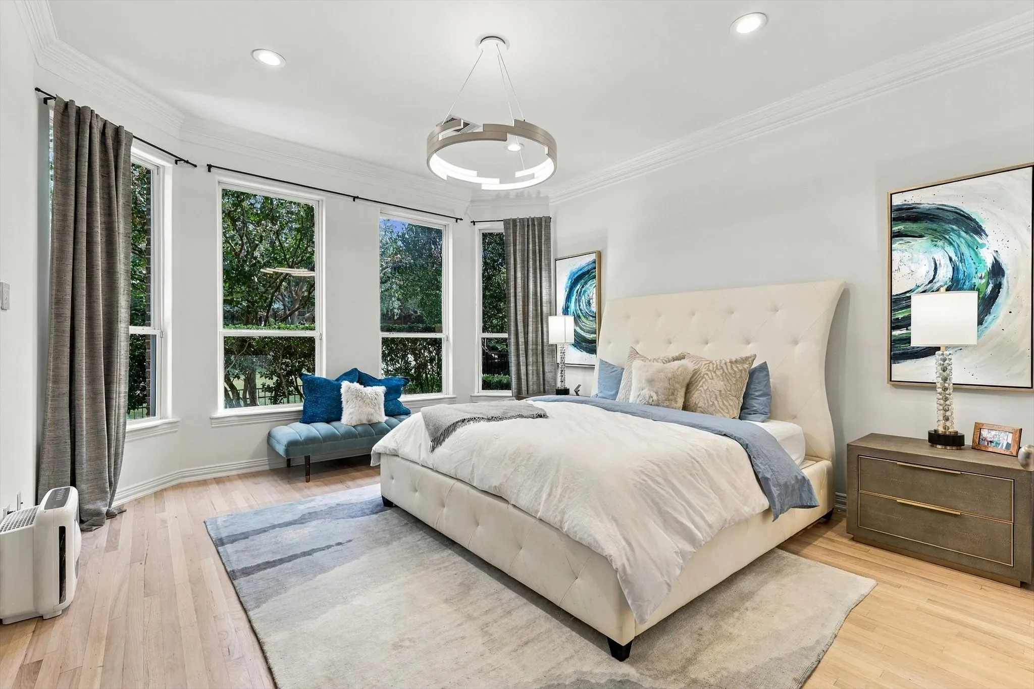 Light wood-finish flooring with recessed lighting and crown molding