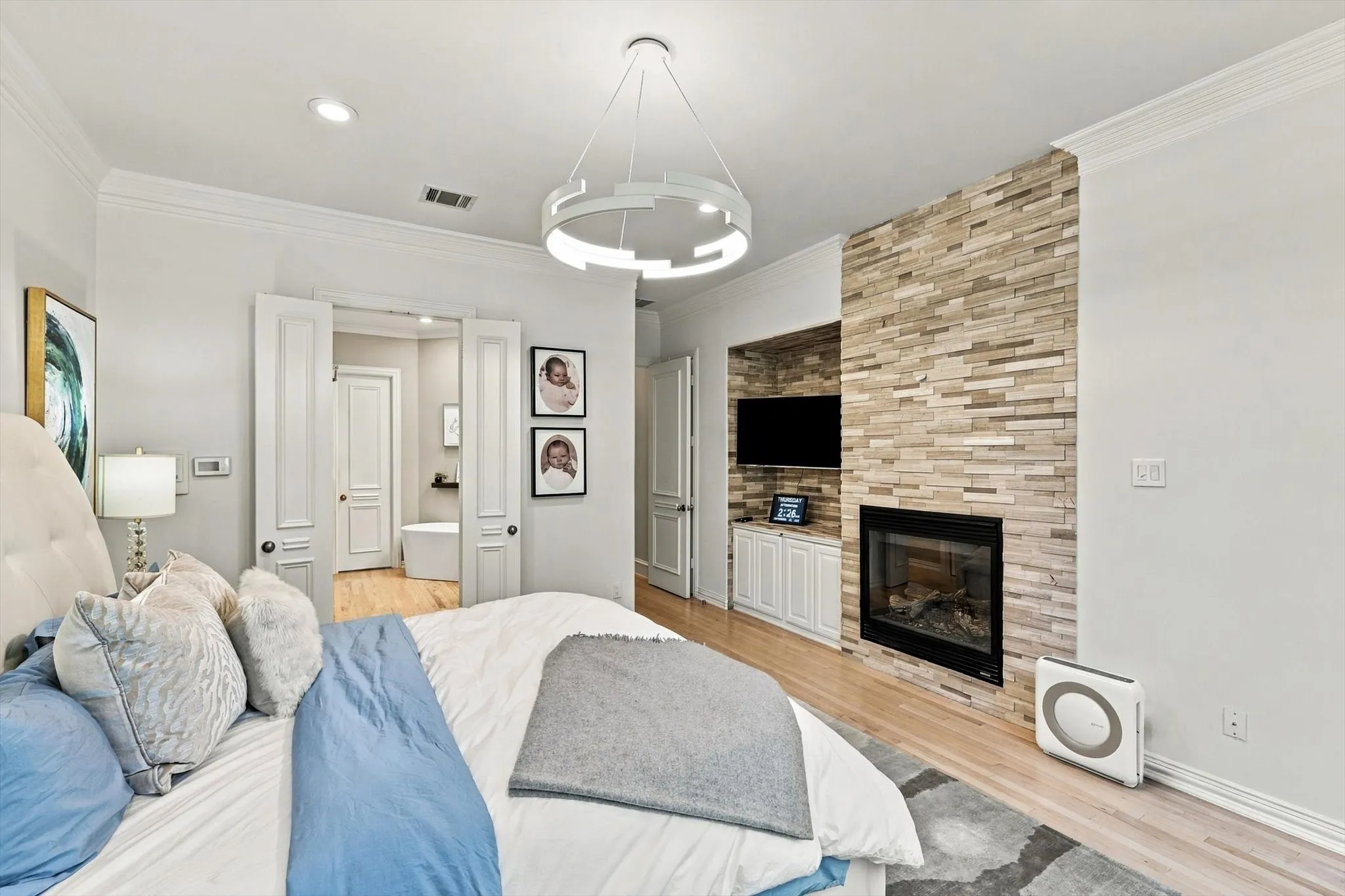 Stacked stone fireplace with a recessed television niche and built-in cabinetry