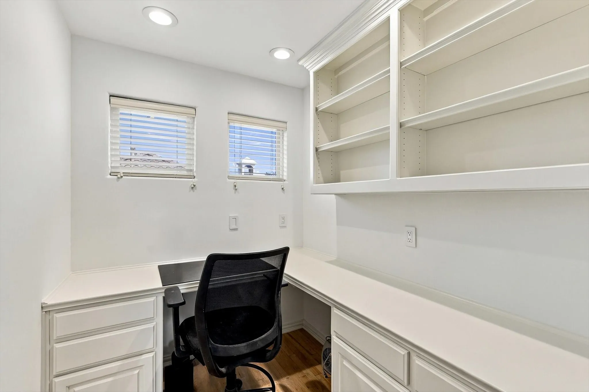 Built-in desk with integrated cabinetry, recessed lighting, and built-in shelving