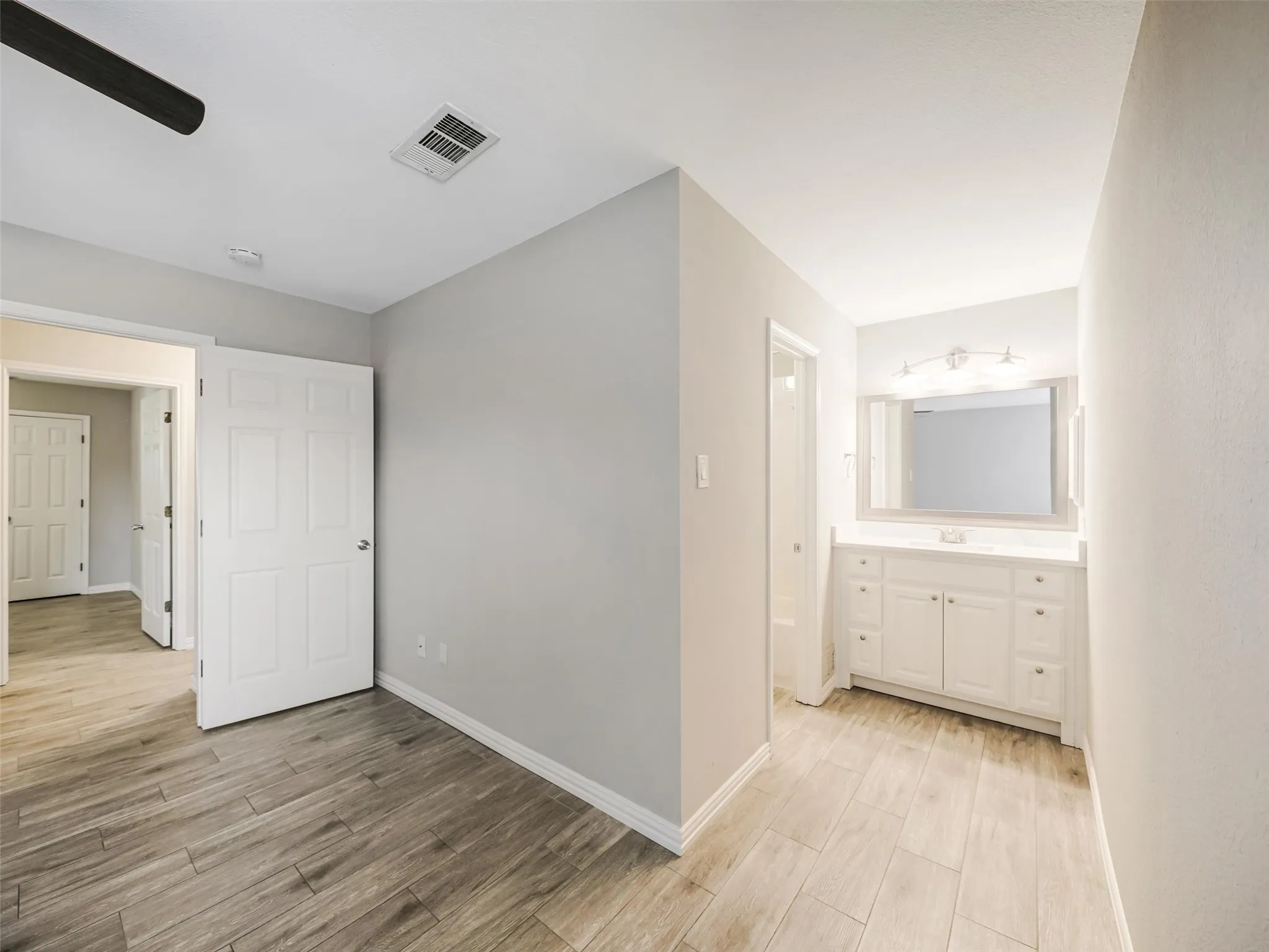 Light wood-finish flooring extends through the space