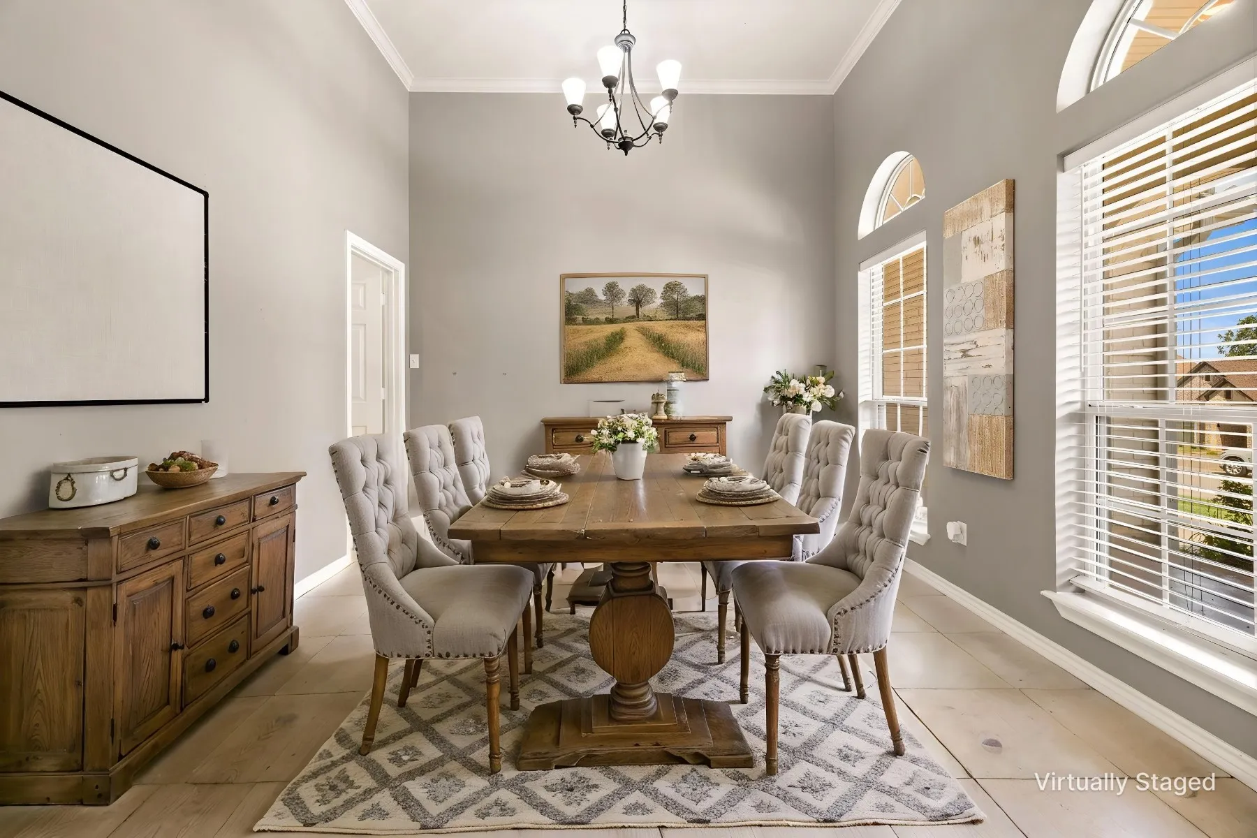 Vaulted ceiling with crown molding, wood-finish flooring, multiple arched windows, and a classic chandelier