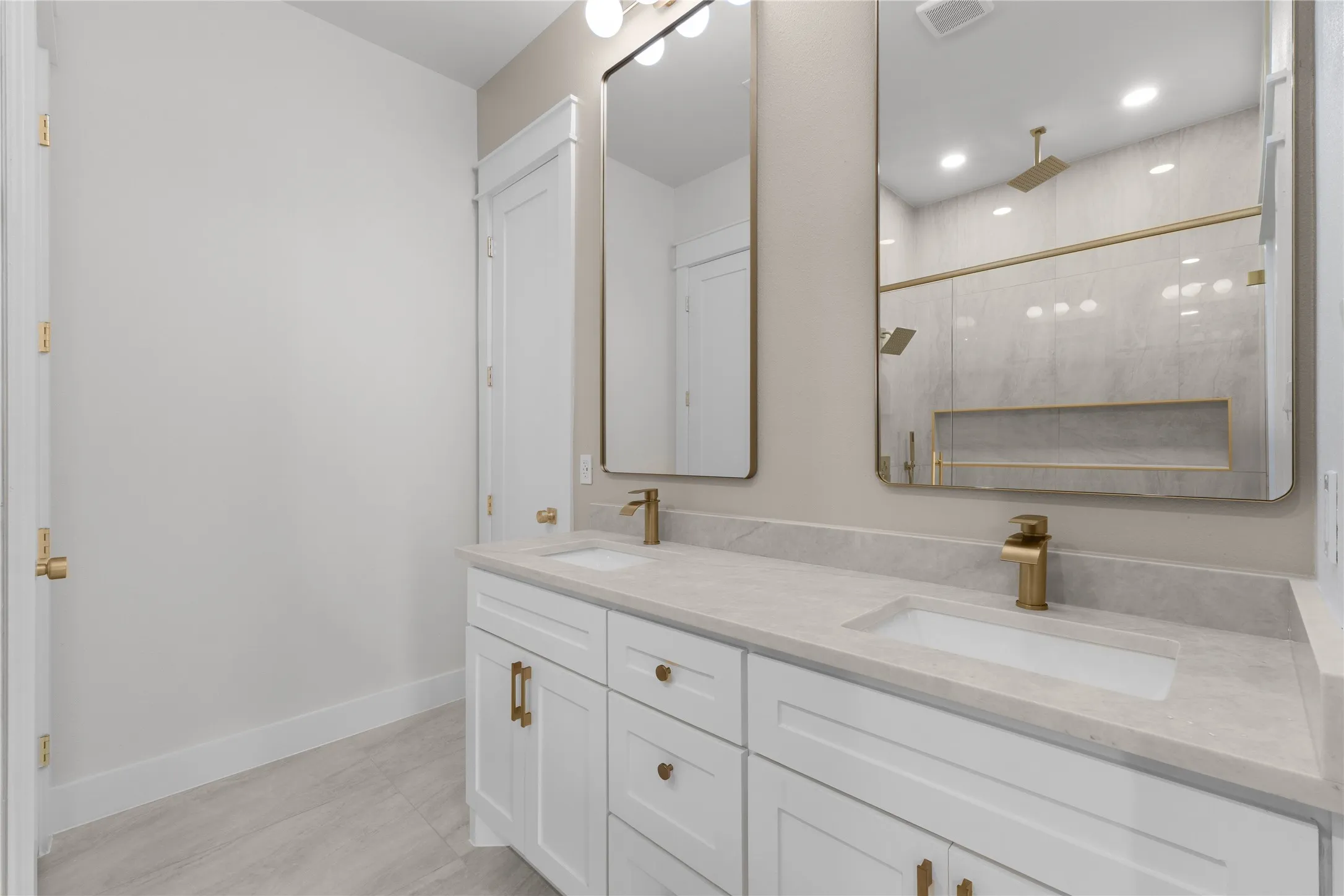 Dual vanity with integrated sinks, light-toned countertop, and gold-finish fixtures