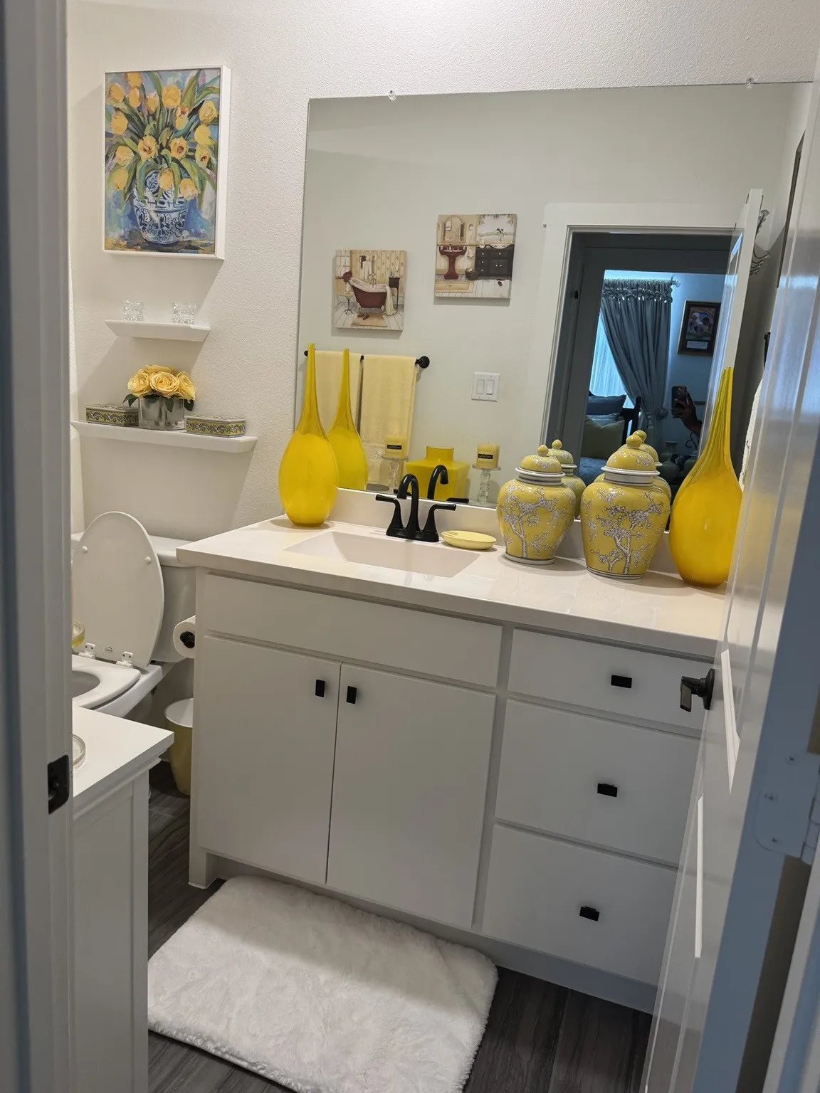 Spacious vanity with a light countertop, integrated sink, and dark hardware