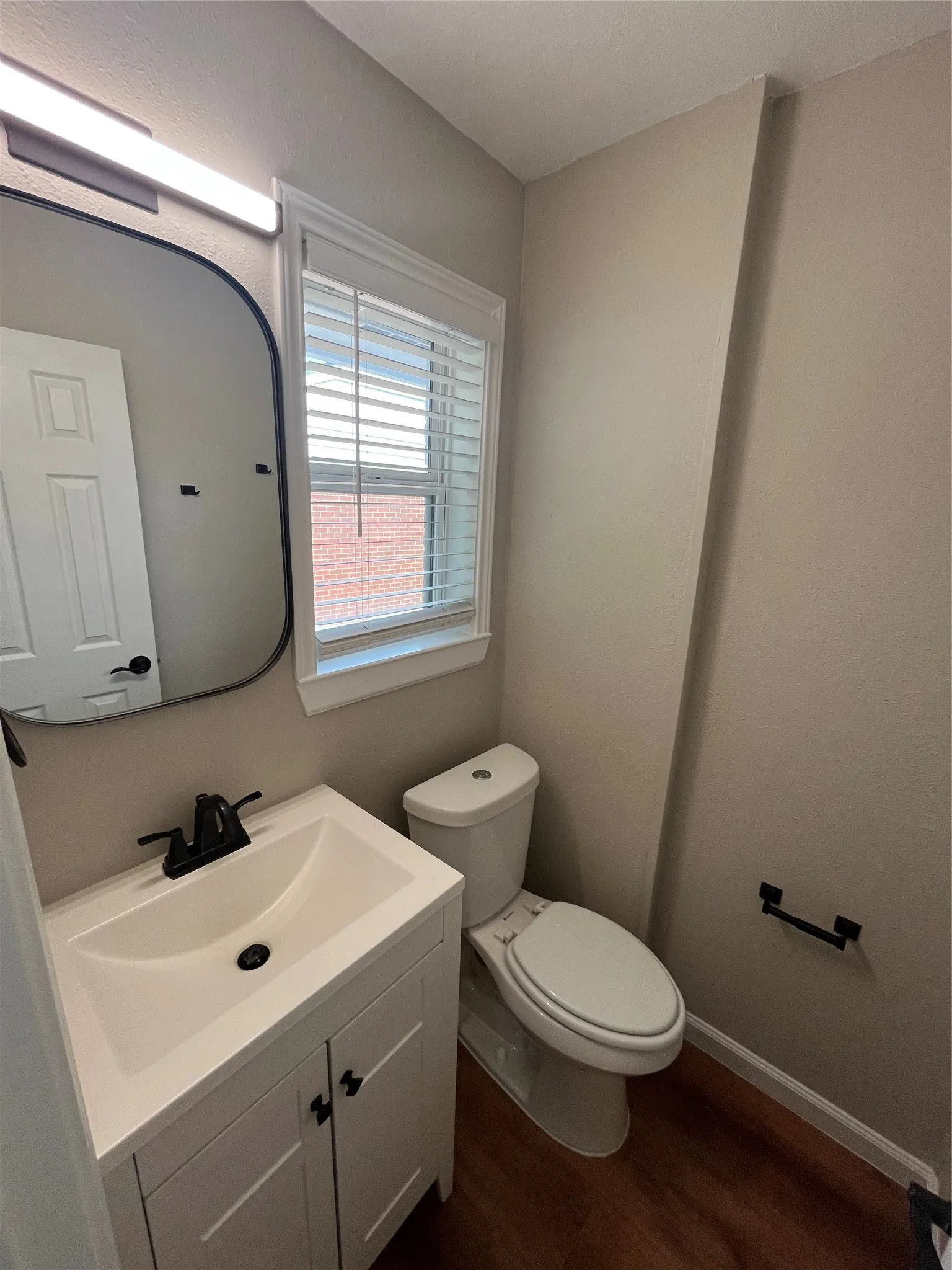 Vanity with integrated sink, matte black faucet, and cabinet storage