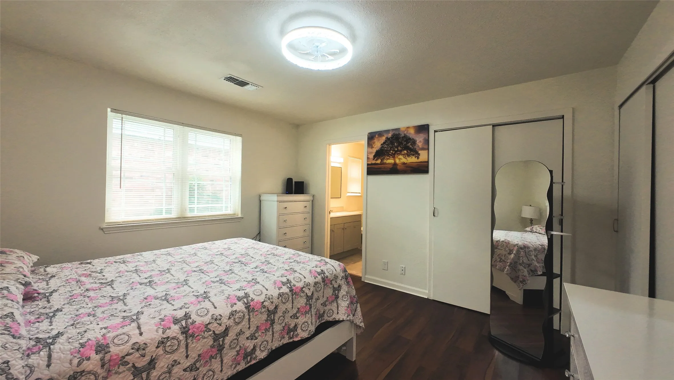 Wood-finish flooring, white walls, built-in sliding closet doors, and recessed lighting
