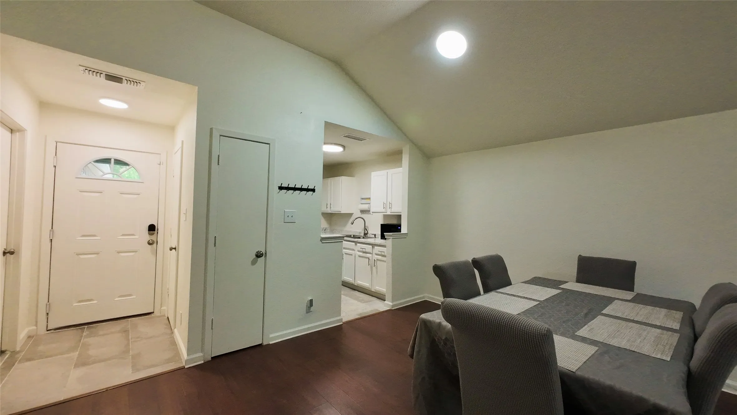 Vaulted ceiling over dining area with wood-finish flooring