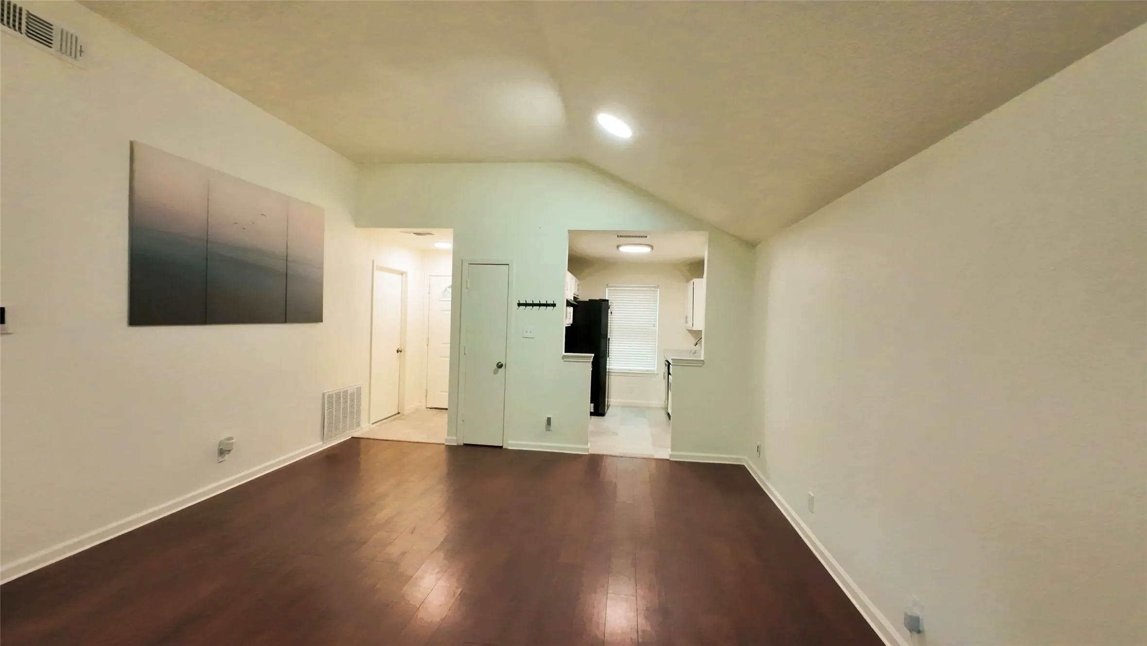 Wood-finish flooring, vaulted ceiling, and recessed lighting