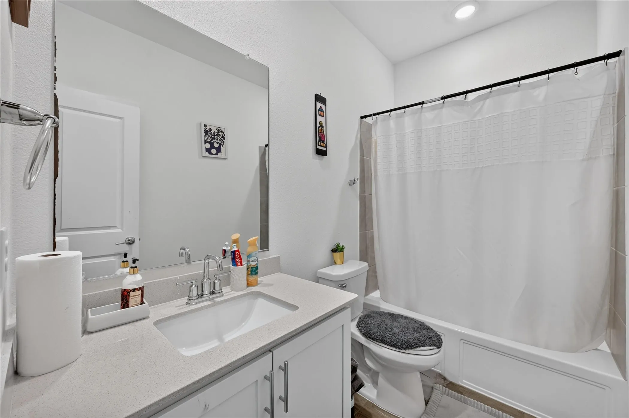 Vanity with integrated sink, stone-finish countertop, and chrome faucet