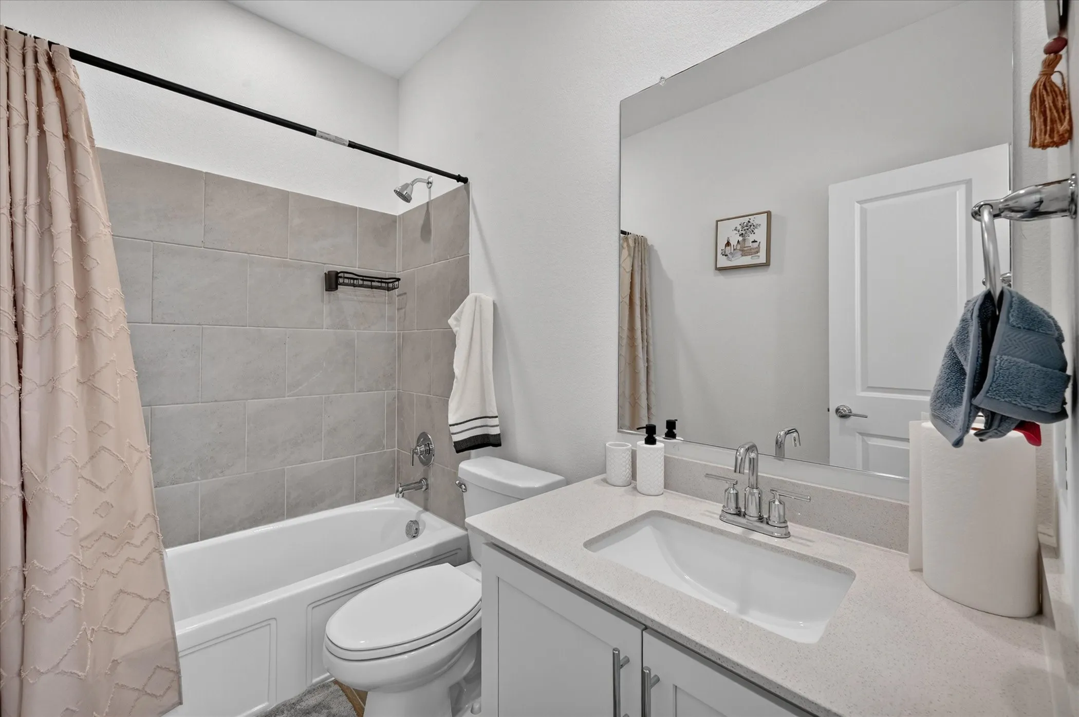 White vanity with double-door cabinetry, light-colored countertop, and integrated rectangular sink
