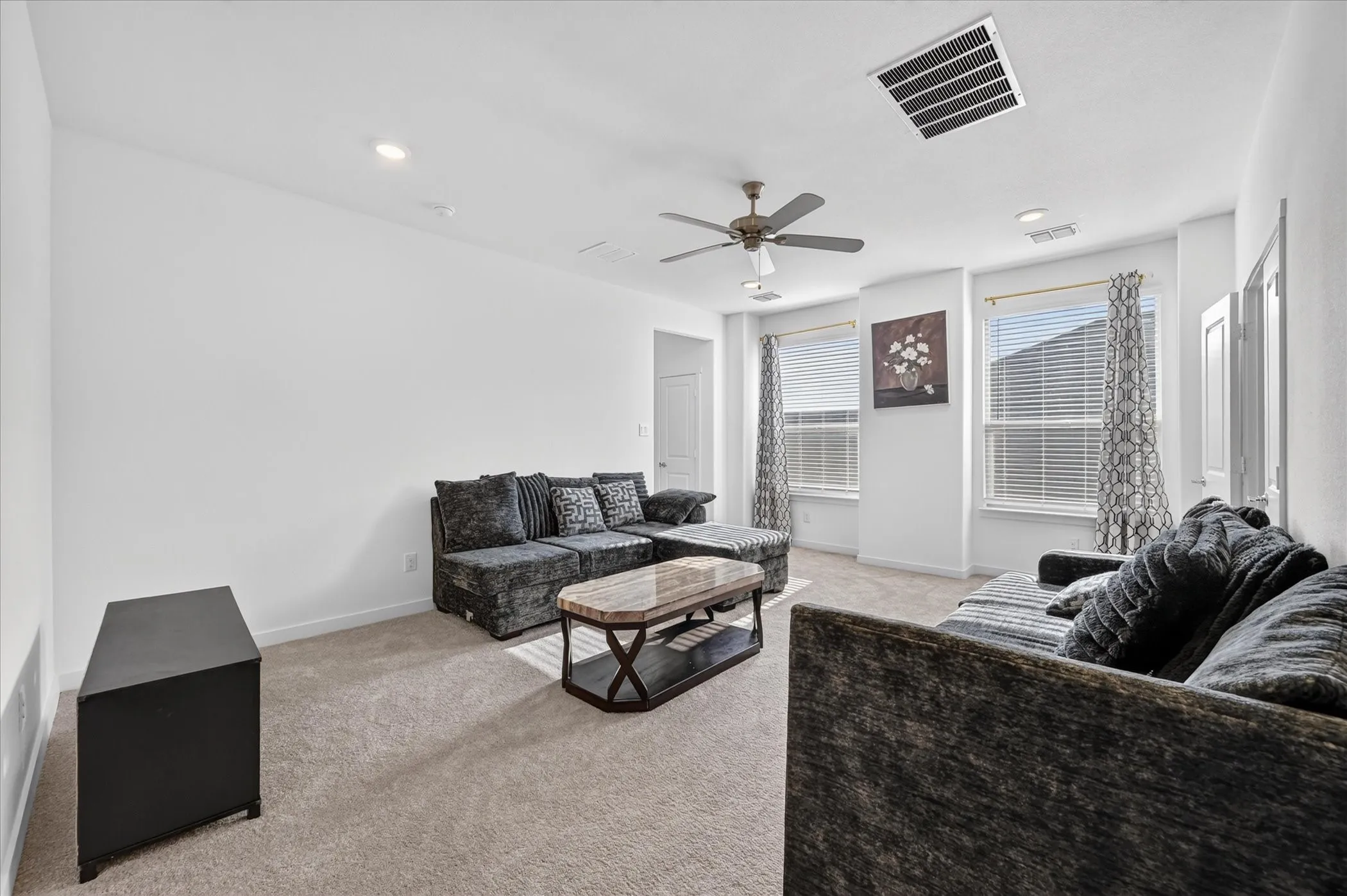 Recessed lighting, ceiling fan with light fixture, and carpet flooring