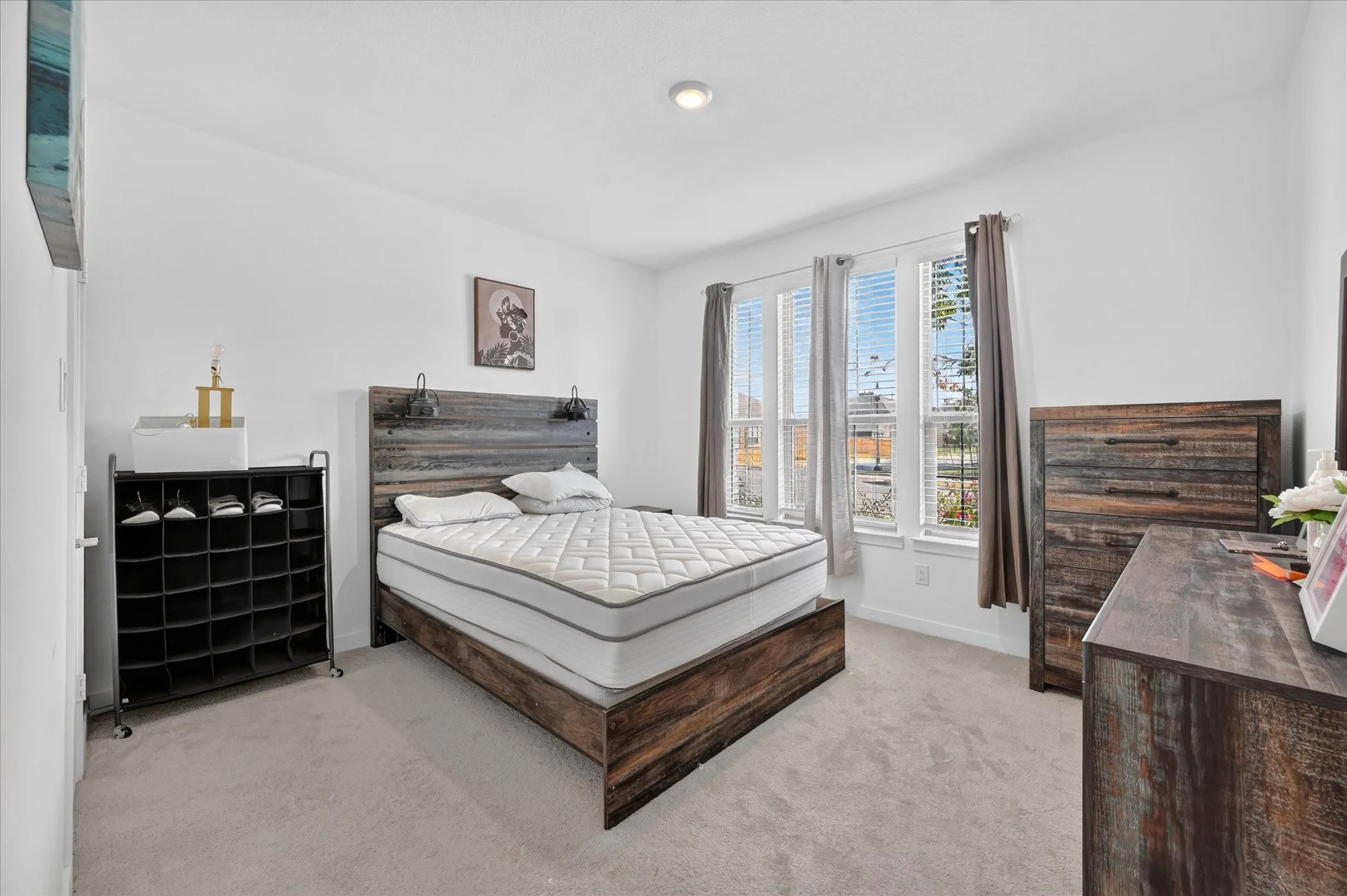 Recessed ceiling lighting, multiple windows with blinds, light-toned carpeting, and white wall finishes