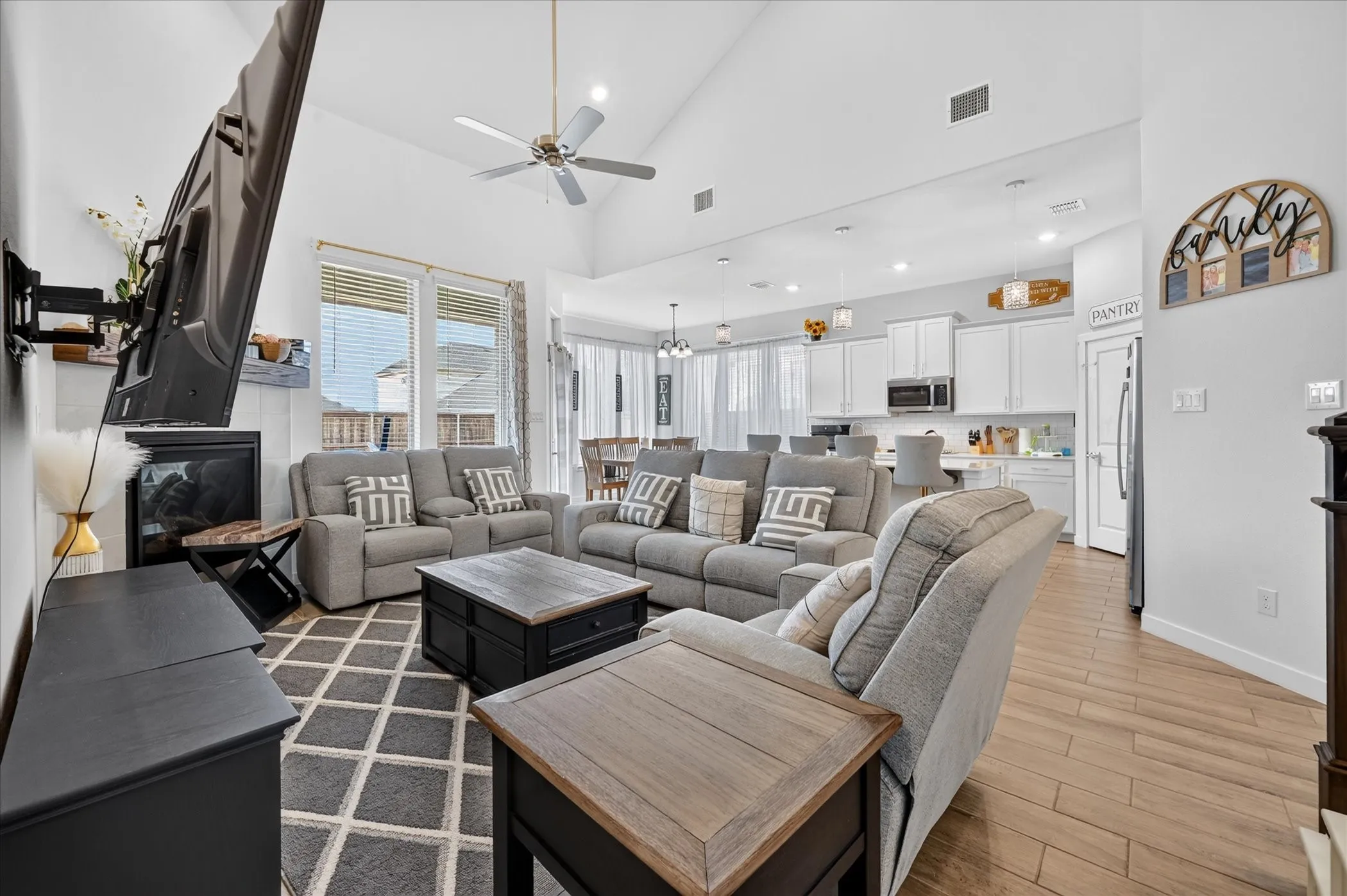 Vaulted ceiling with a ceiling fan, recessed lighting, and wood-finish flooring