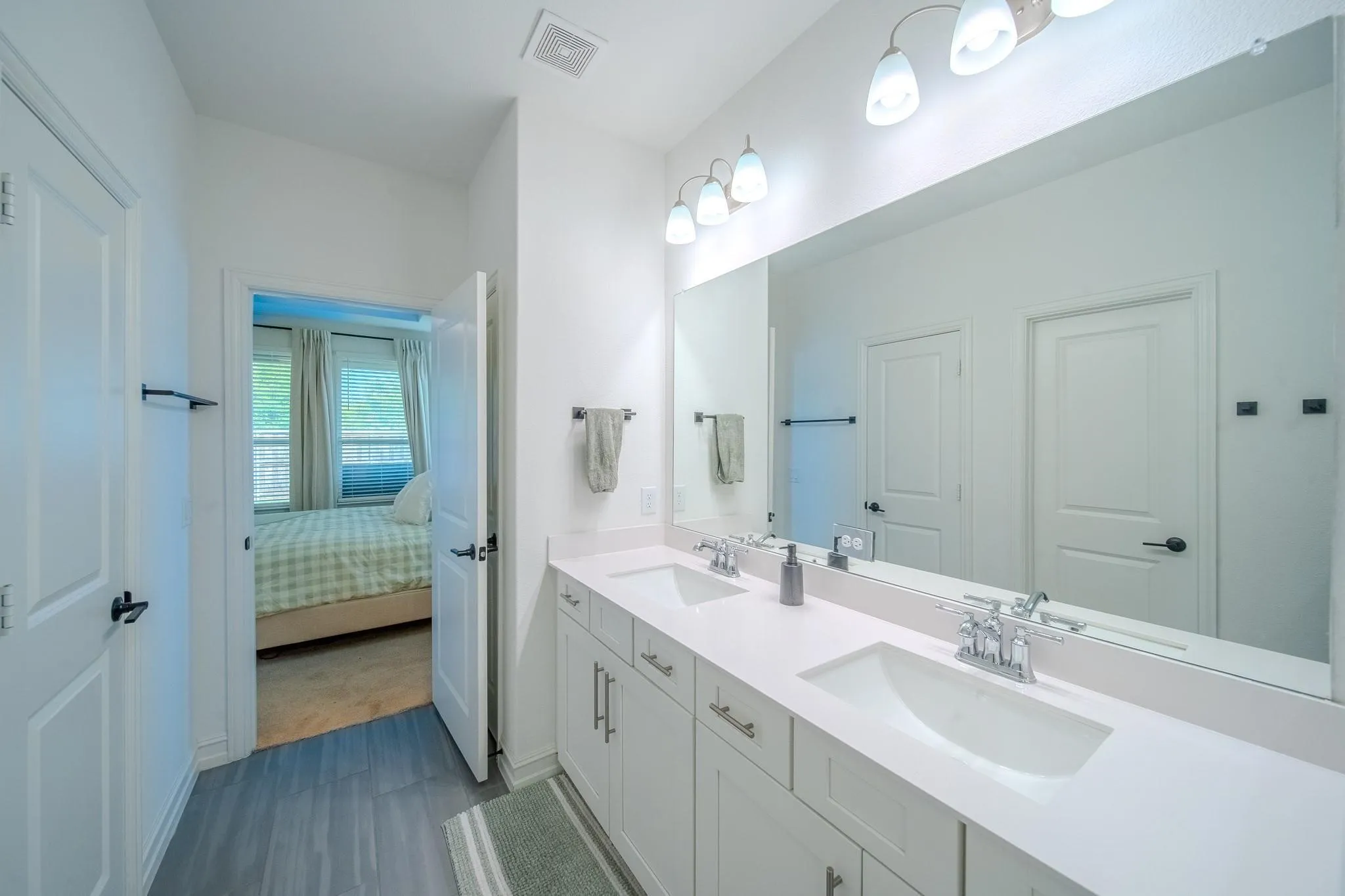 Dual vanity with undermount sinks, chrome fixtures, and a large mirror
