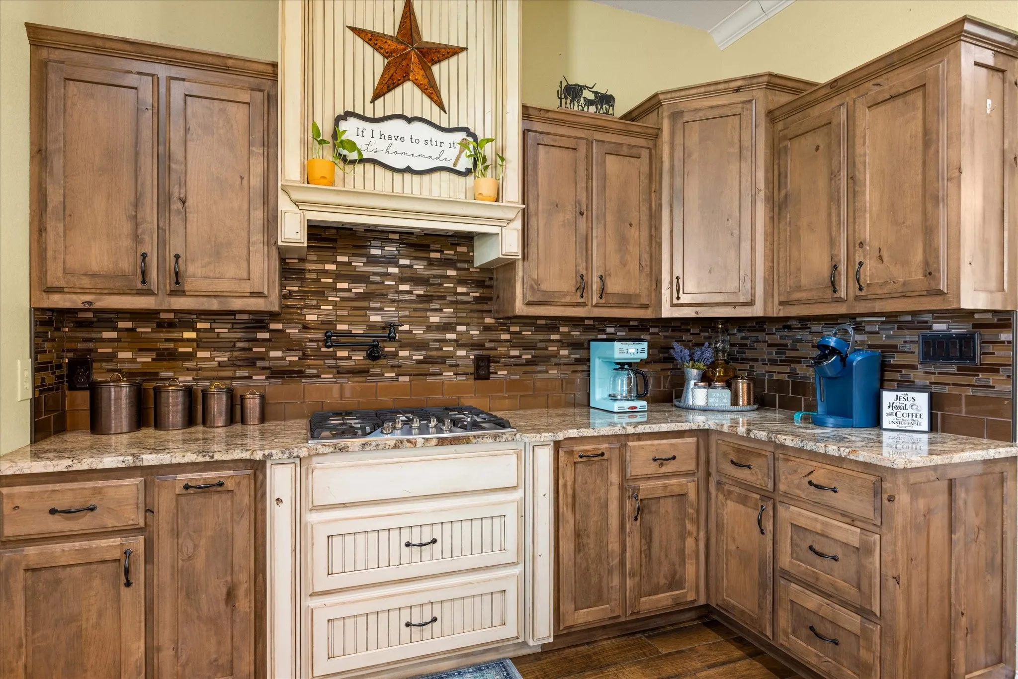 Gas cooktop with a pot filler, and gorgeous custom cabinets.