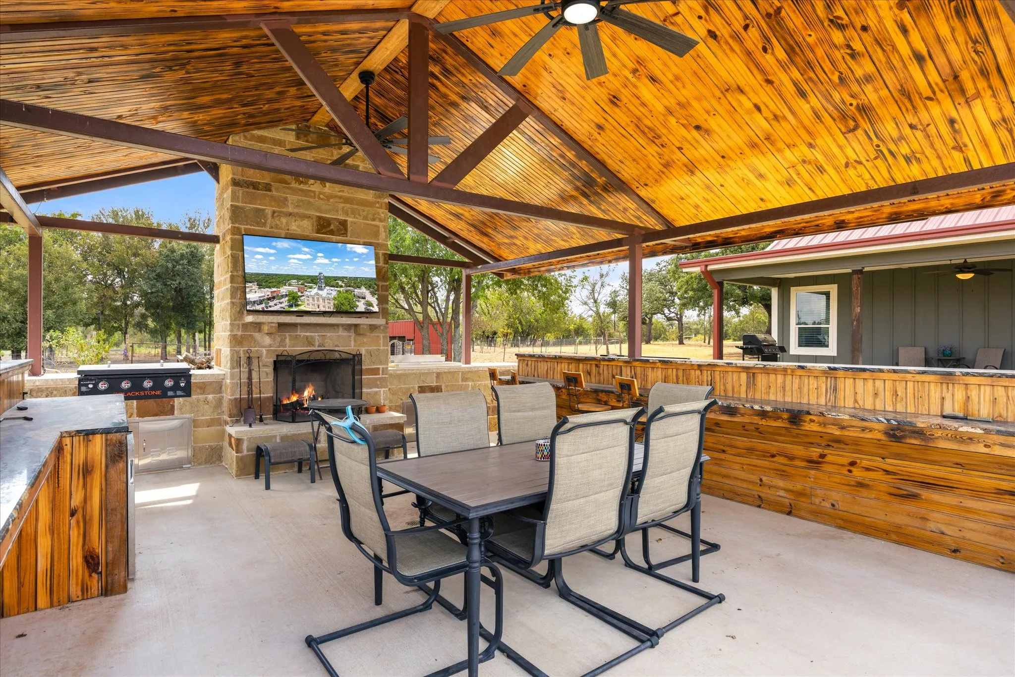 Outdoor pavilion includes fireplace, Blackstone, and lots of seating space for entertaining.