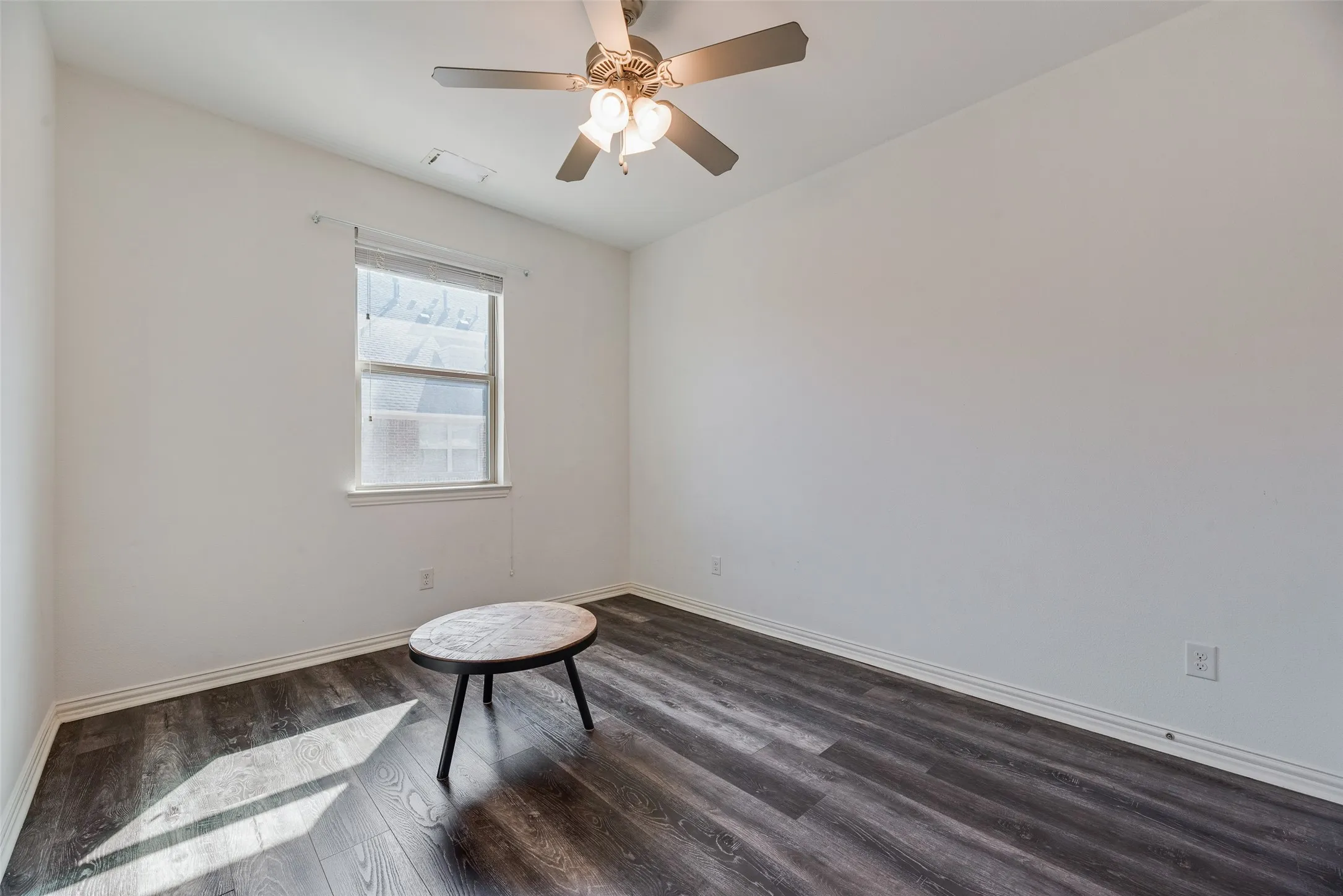 Recessed window, ceiling fan with integrated lighting, and wood-finish flooring