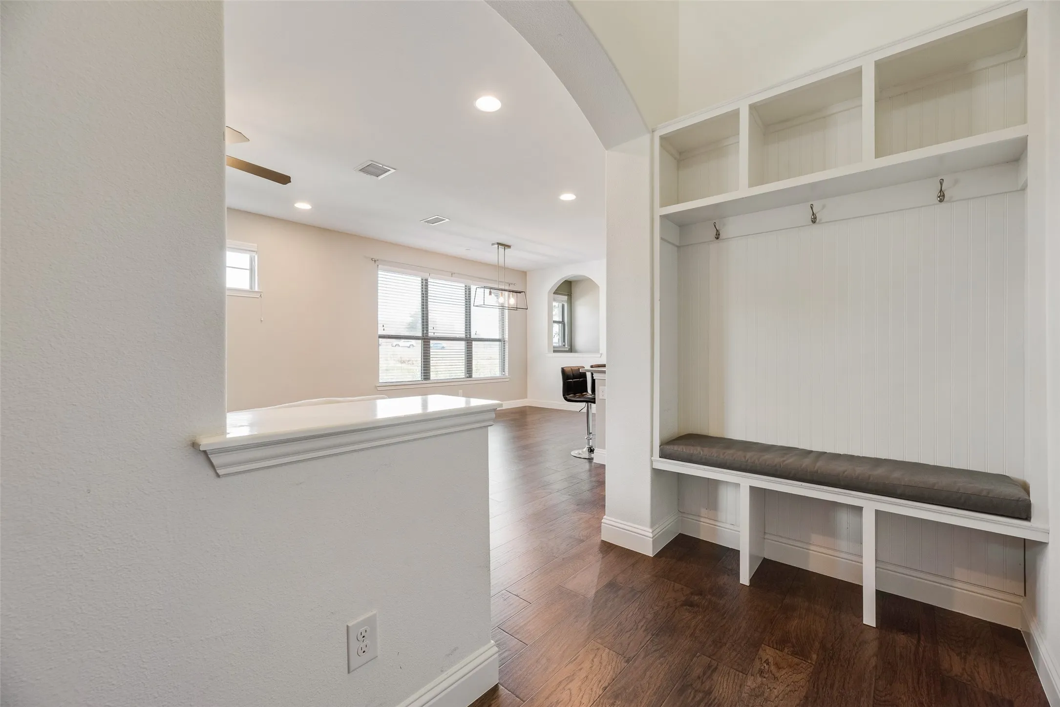 Built-in mudroom bench with storage, overhead shelving, and wall hooks