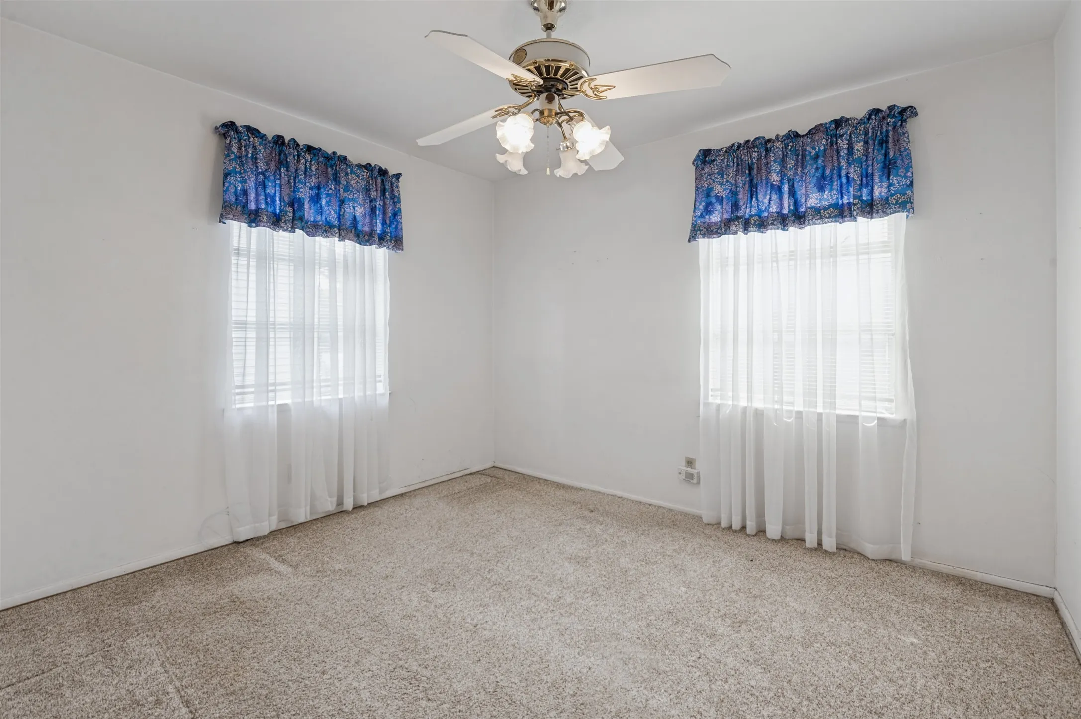 Recessed windows with blinds, wall-to-wall carpeting, and a ceiling fan with light fixture