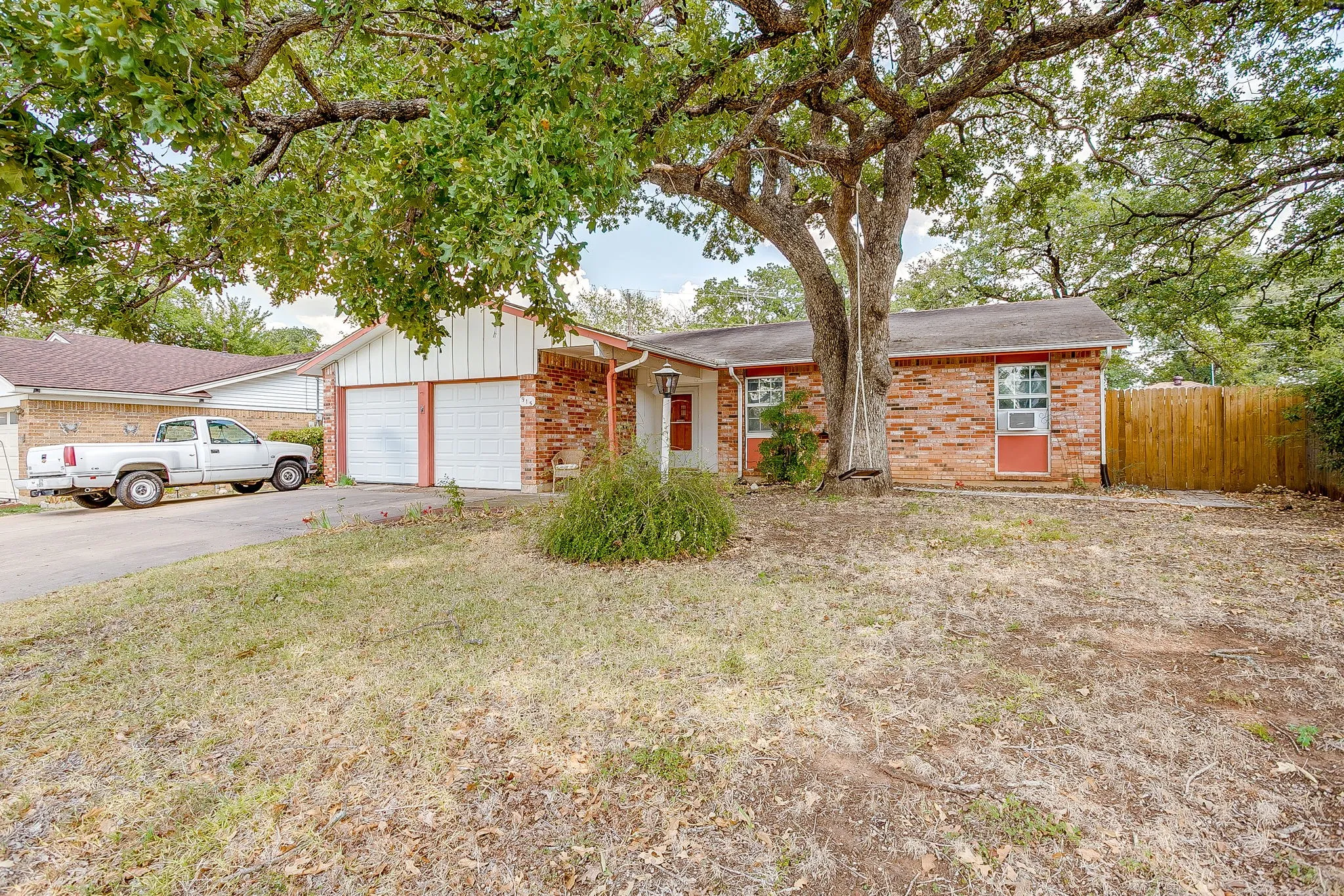 Brick exterior with a mature tree in the front yard