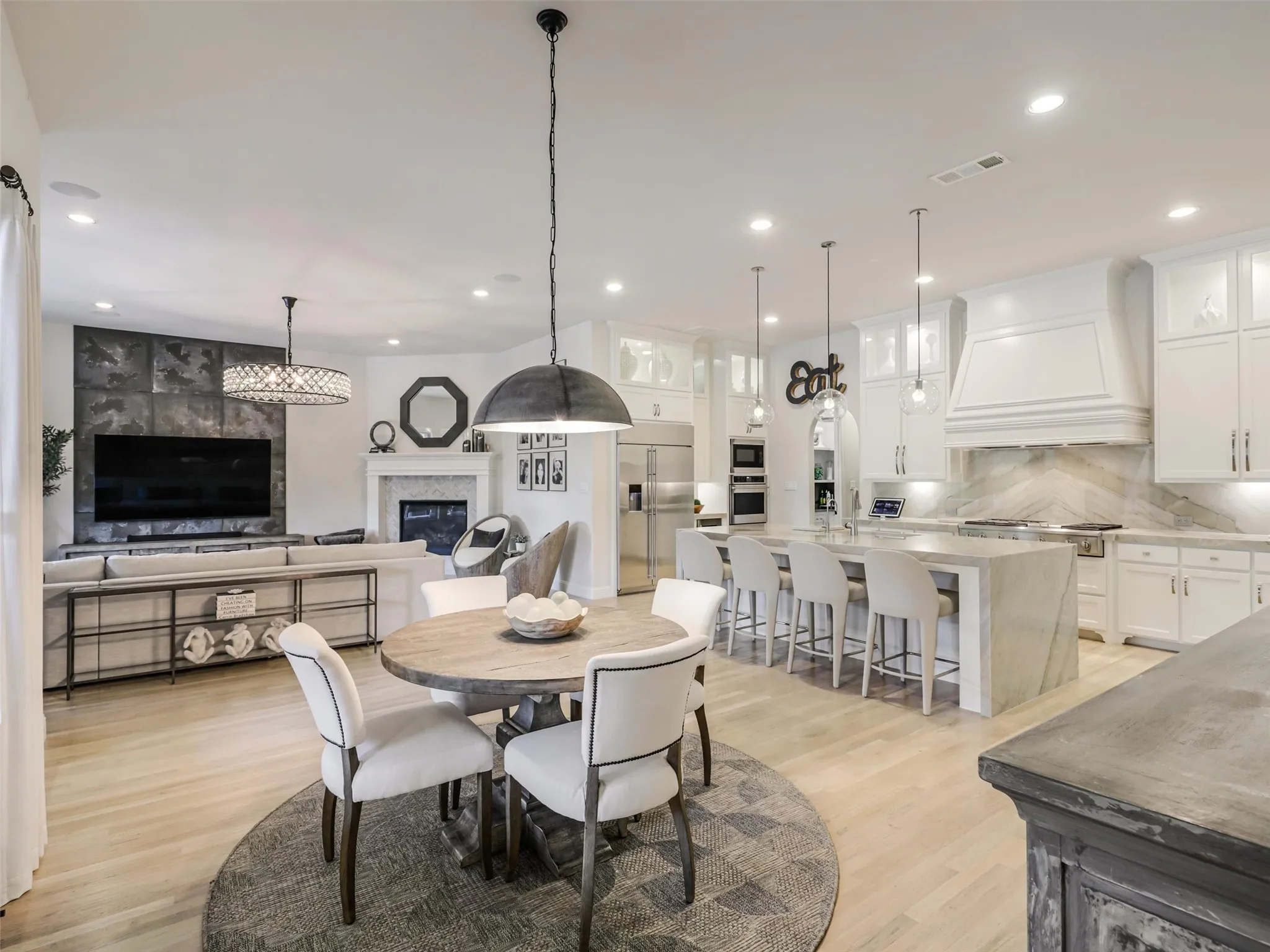 A dedicated breakfast area has direct access to the covered backyard patio. • Quartzite waterfall countertops with matching quartzite backsplash
• Cabinets extended to the ceiling
• Custom pantry
• GE Monogram appliances: built-in refrigerator, double oven, and 48 inch range
• Built-in ice machine and wine refrigerator