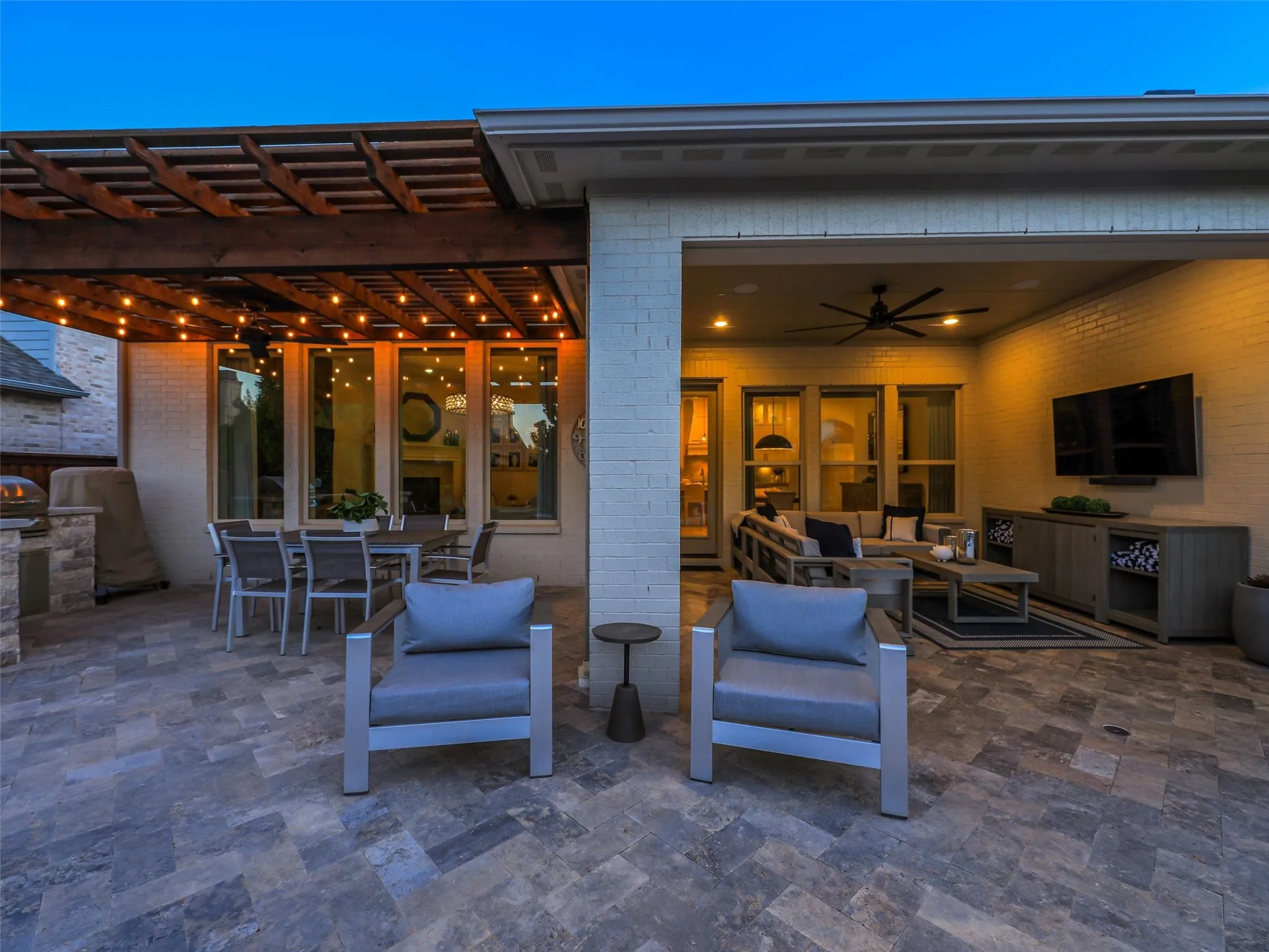 The outdoor living spaces transform the backyard into a private resort. A covered outdoor living center with integrated lighting provides a comfortable place to relax or entertain,  • Custom pool and spa ranging from 3.5 ft in the shallow end to 6 ft in the deep end, with basketball hoop
• Baja shelf with lounge chaises and table
• 5 Jandy pool lights, recently replaced
• Silver travertine decking throughout pool and patio
• Pergola over outdoor living area
• Built-in outdoor kitchen with Bull grill and Bull refrigerator
• Fire pit patio
• Artificial turf, approx. 21 ft x 38 ft
• Mature landscaping with landscape lighting
• Decorative rock: approx. 15 tons of large Texas black rock and 3 tons of black Mexican river stone
• Built-in speakers in the patio ceiling and throughout the pool and landscape areas