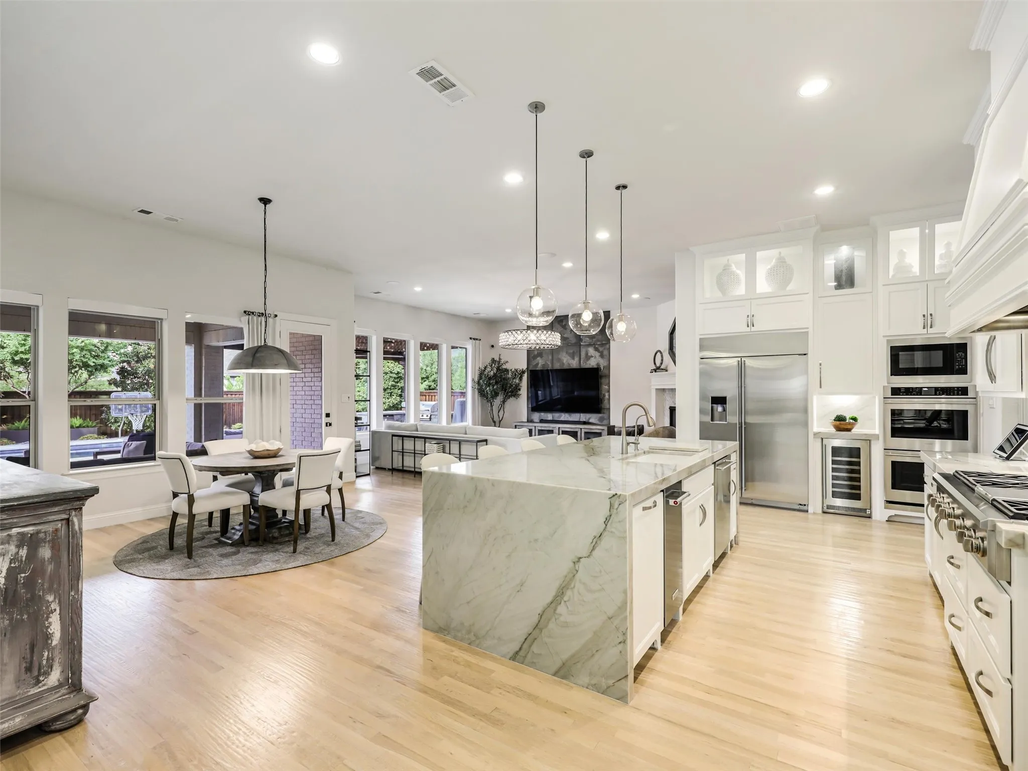 At the heart of the home is an exceptional chef­inspired kitchen designed for both everyday living and large-scale entertaining. Pendant and recessed lighting complement the space, while a walk-in pantry and separate butler's pantry provide additional storage and serving areas. • Quartzite waterfall countertops with matching quartzite backsplash
• Cabinets extended to the ceiling
• Custom pantry
• GE Monogram appliances: built-in refrigerator, double oven, and 48 inch range
• Built-in ice machine and wine refrigerator