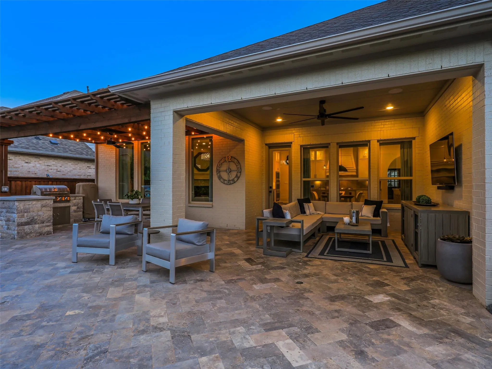 Beyond the pool, the fully fenced backyard features low-maintenance turf landscaping and a separate fire pit patio, creating multiple outdoor gathering spaces for entertaining, relaxing, and enjoying evenings at home. • Custom pool and spa ranging from 3.5 ft in the shallow end to 6 ft in the deep end, with basketball hoop
• Baja shelf with lounge chaises and table
• 5 Jandy pool lights, recently replaced
• Silver travertine decking throughout pool and patio
• Pergola over outdoor living area
• Built-in outdoor kitchen with Bull grill and Bull refrigerator
• Fire pit patio
• Artificial turf, approx. 21 ft x 38 ft
• Mature landscaping with landscape lighting
• Decorative rock: approx. 15 tons of large Texas black rock and 3 tons of black Mexican river stone
• Built-in speakers in the patio ceiling and throughout the pool and landscape areas.