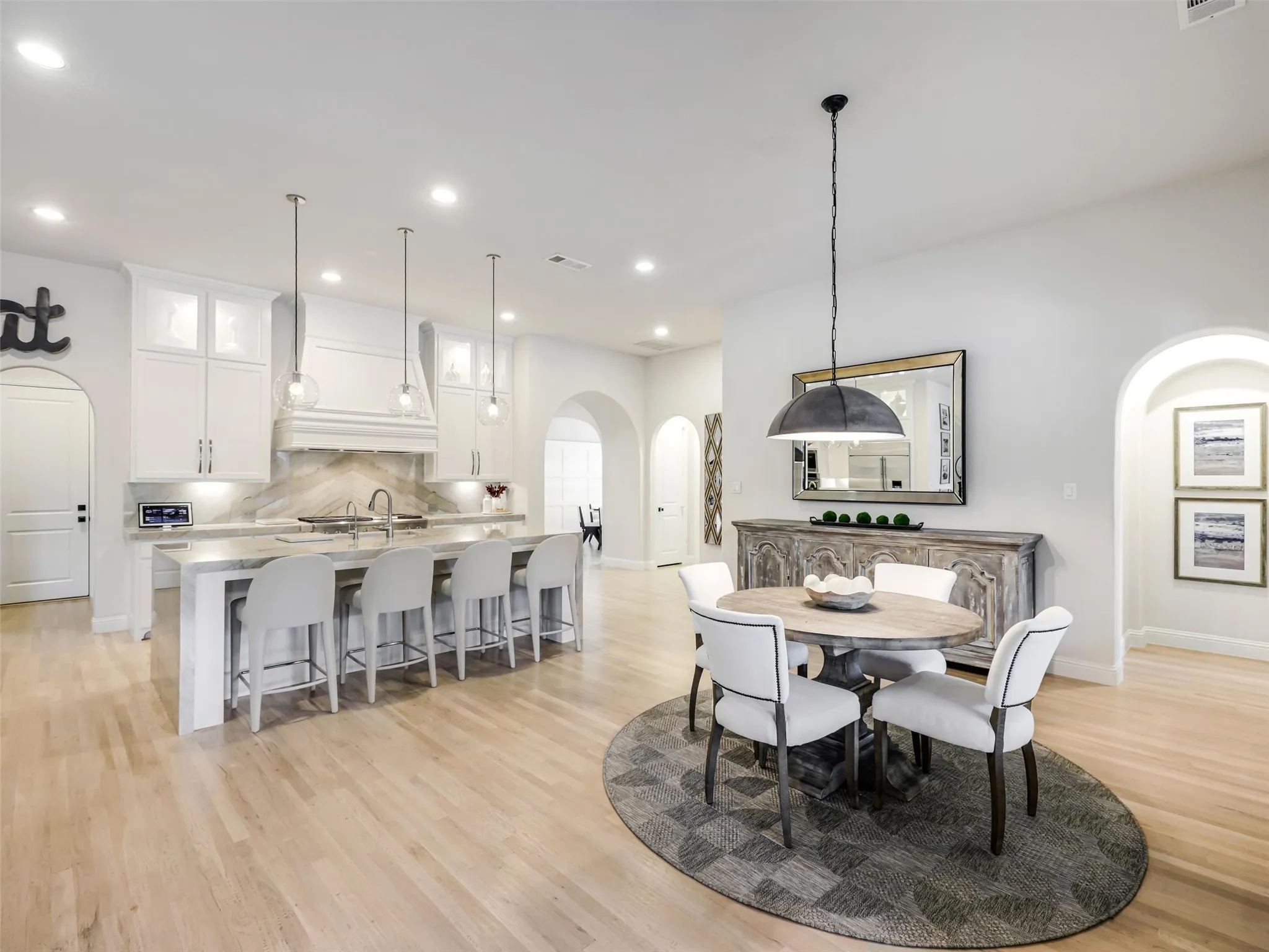 A dedicated breakfast area has direct access to the covered backyard patio. • White oak flooring throughout the first floor
• Foyer: Restoration Hardware chandelier
• Dining room: custom carpentry and Williams Sonoma chandelier
• Office: custom built-ins
• Game room: custom carpentry and dry bar
• Media room: Epson 4K projector