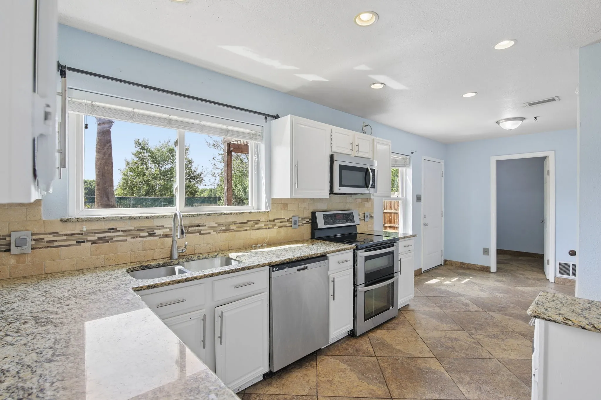 The kitchen with attached breakfast area features granite counters, SS appliances, and a double oven!