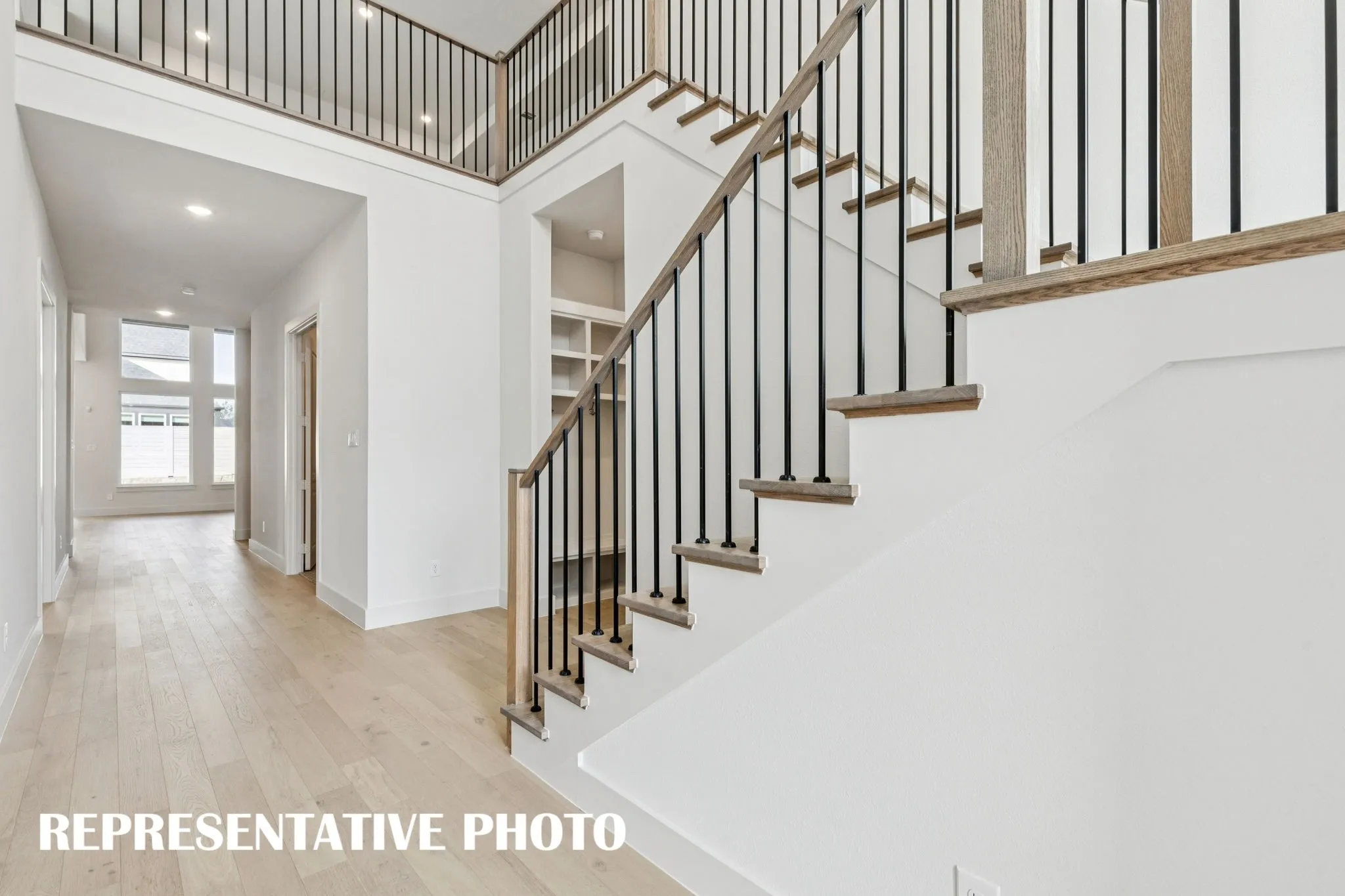 Featuring high ceilings, beautiful flooring, striking metal railings and sight lines from the front through to the rear of the home, the entry of our Addison III plan offers a grand space for you to welcome friends and family!  REPRESENTATIVE PHOTO