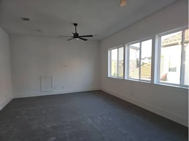 Recessed lighting, ceiling fan, three white-framed windows, and carpeted flooring