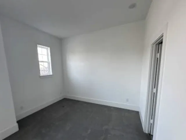 Recessed ceiling lighting, a single pane window, white painted walls, and a bi-fold closet door