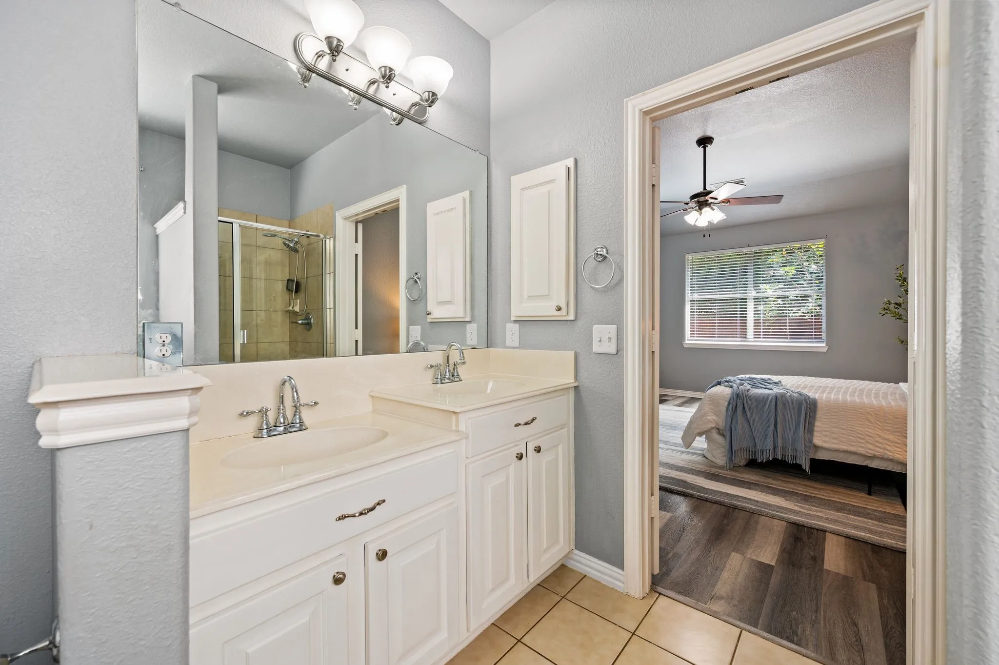 Double vanity with integrated sinks, brushed nickel fixtures, and a large mirror