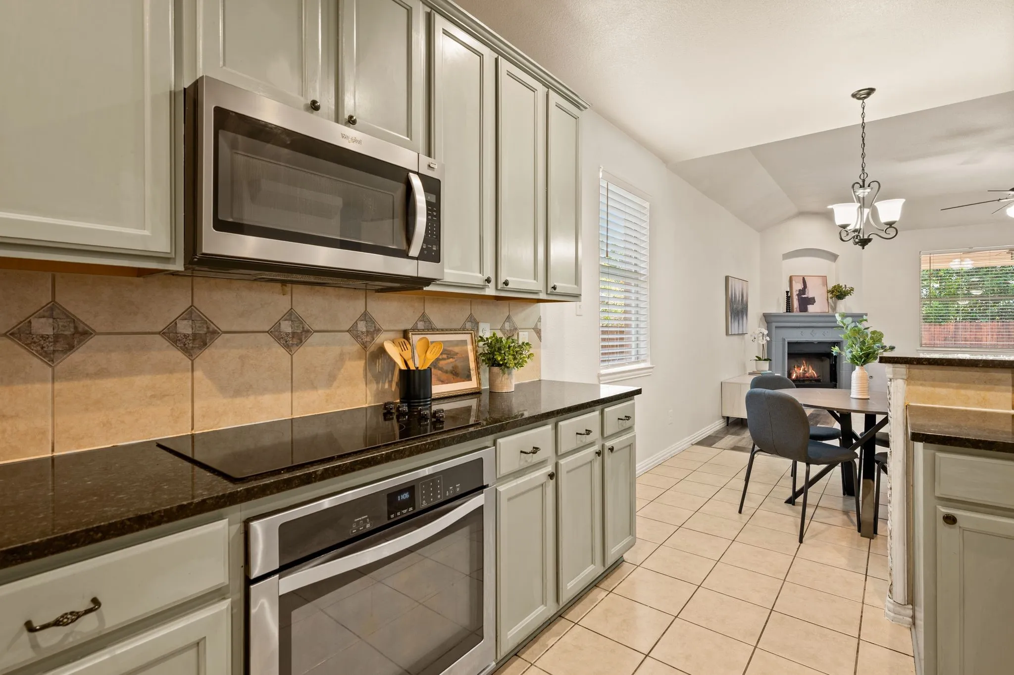 Kitchen featuring painted cabinetry, stainless steel microwave, and dark countertops