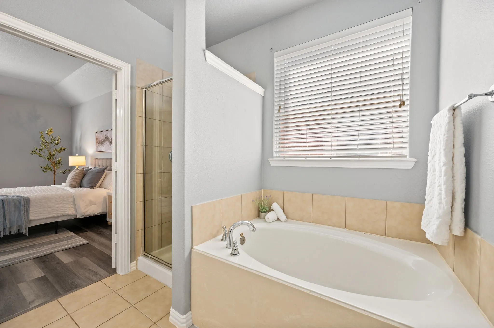 Built-in corner tub with tiled surround, adjacent to a glass-enclosed shower