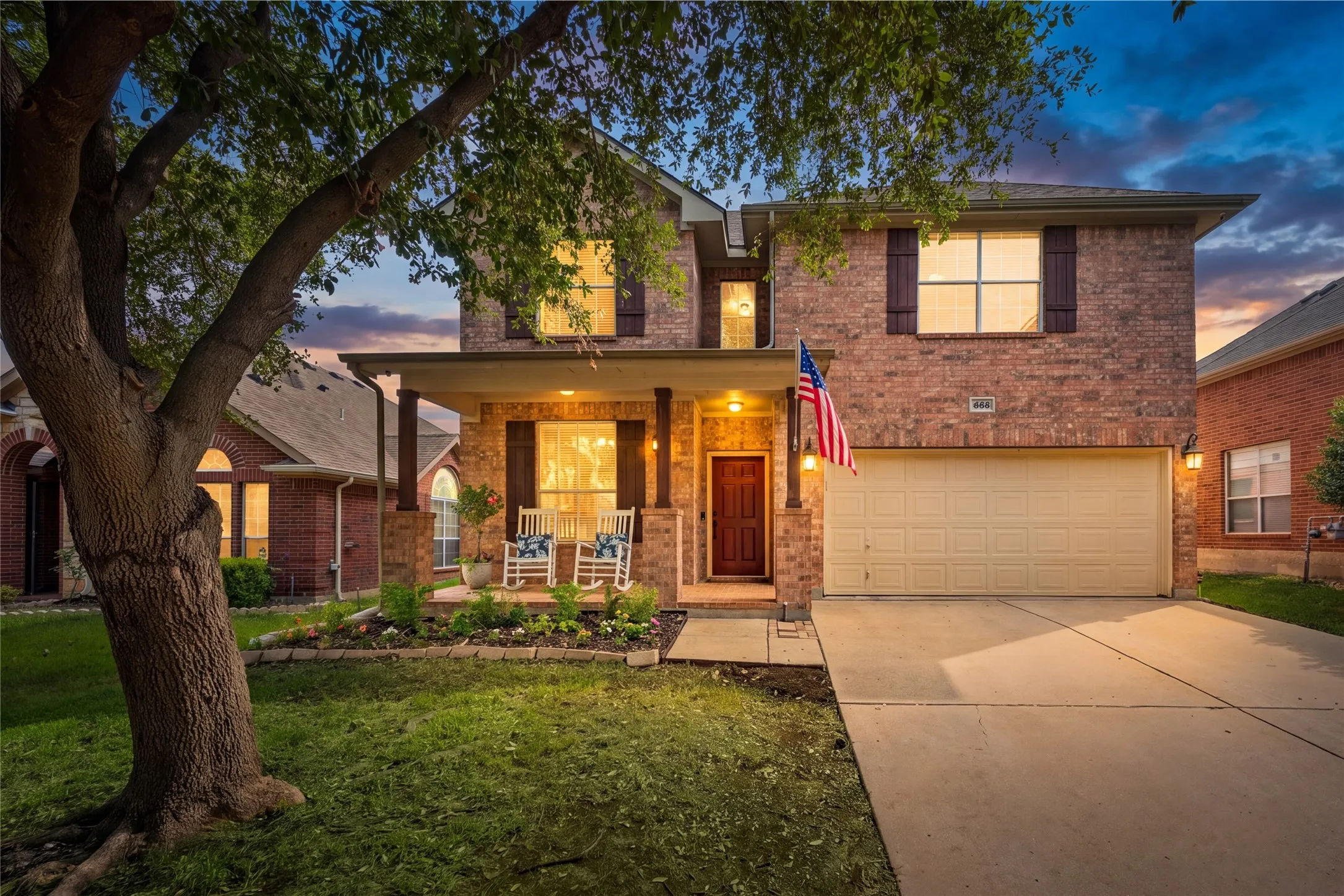Brick facade with dark shutters and a covered front porch featuring architectural columns