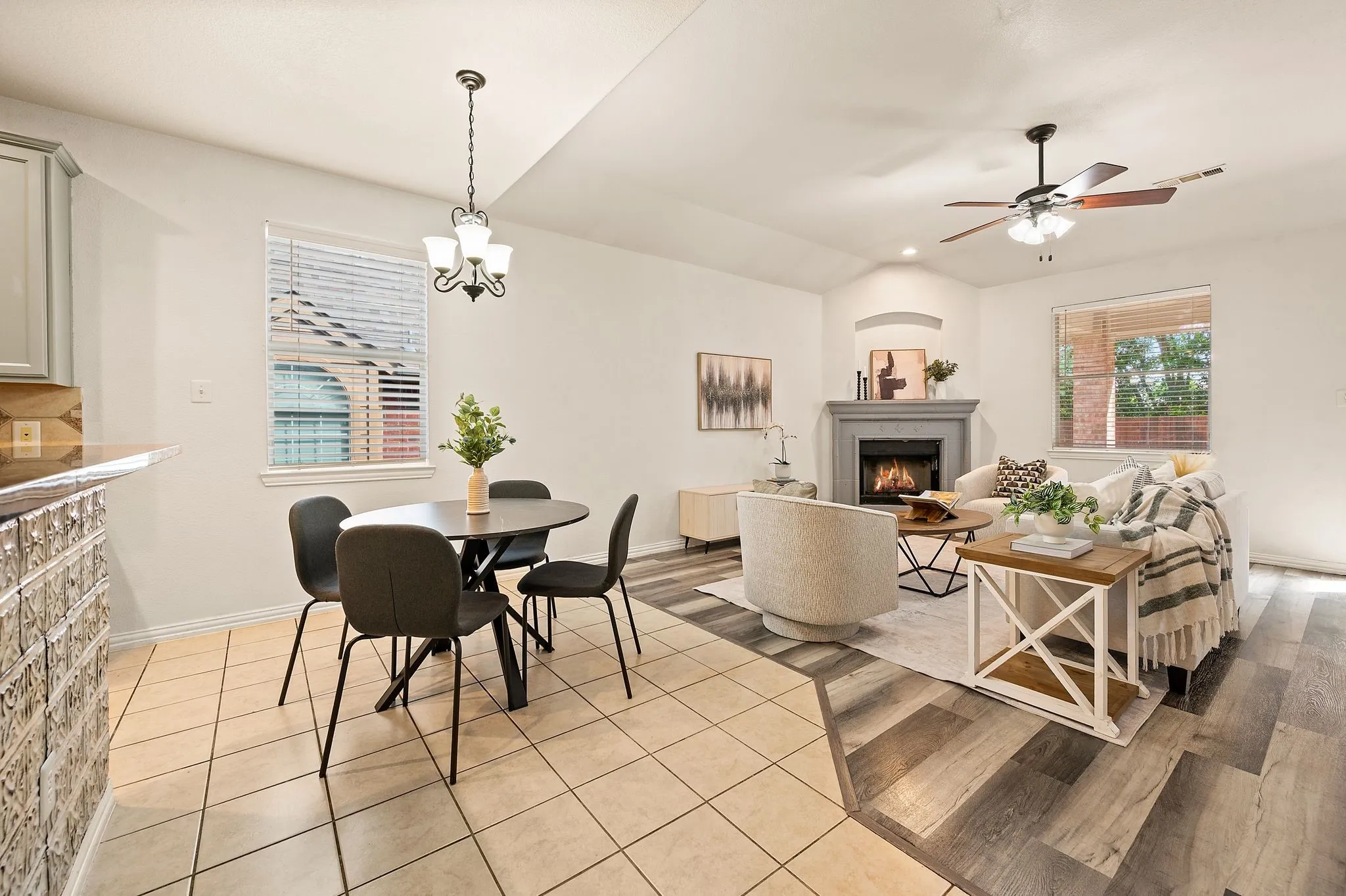 Living area featuring a fireplace with a mantel, a ceiling fan, and wood-finish flooring