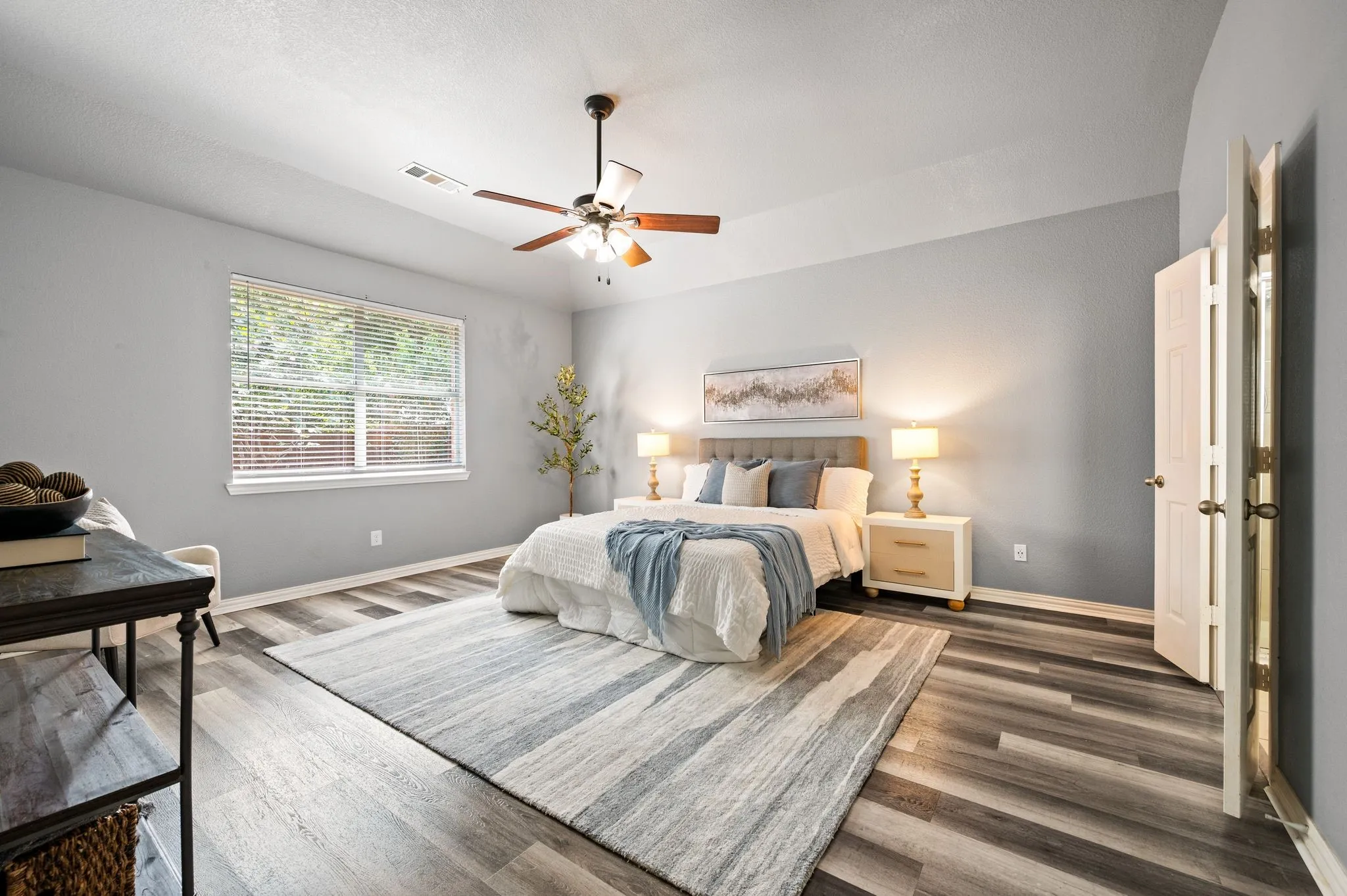Tall ceiling with a ceiling fan, wood-finish flooring, and a window with blinds