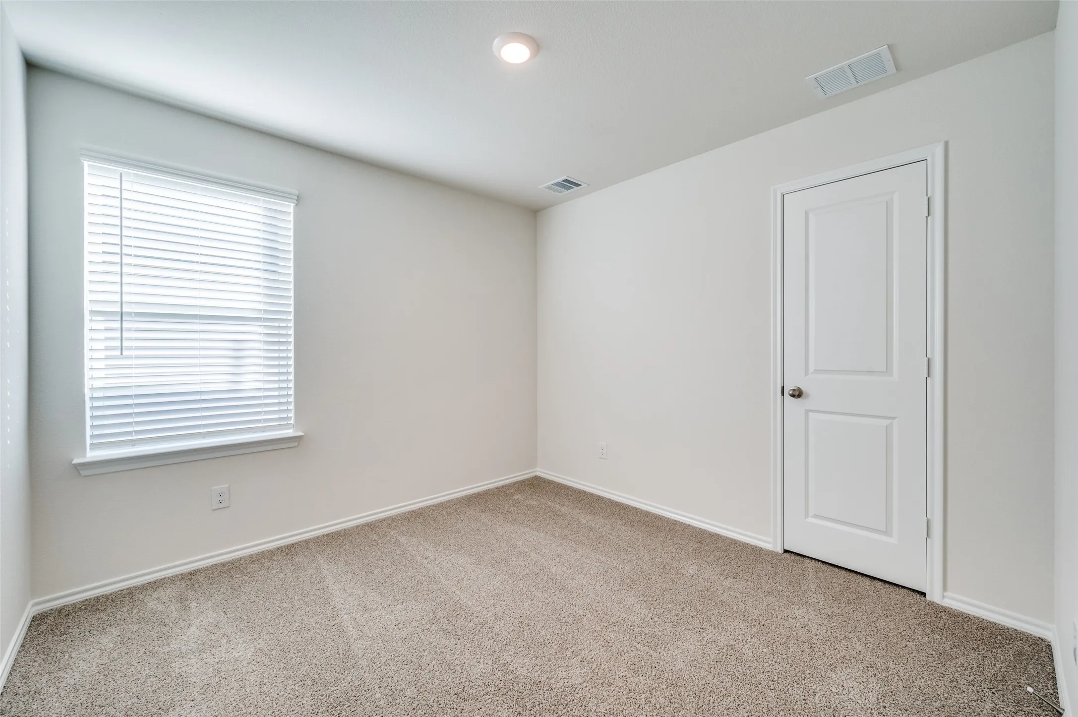 Empty room with light colored carpet