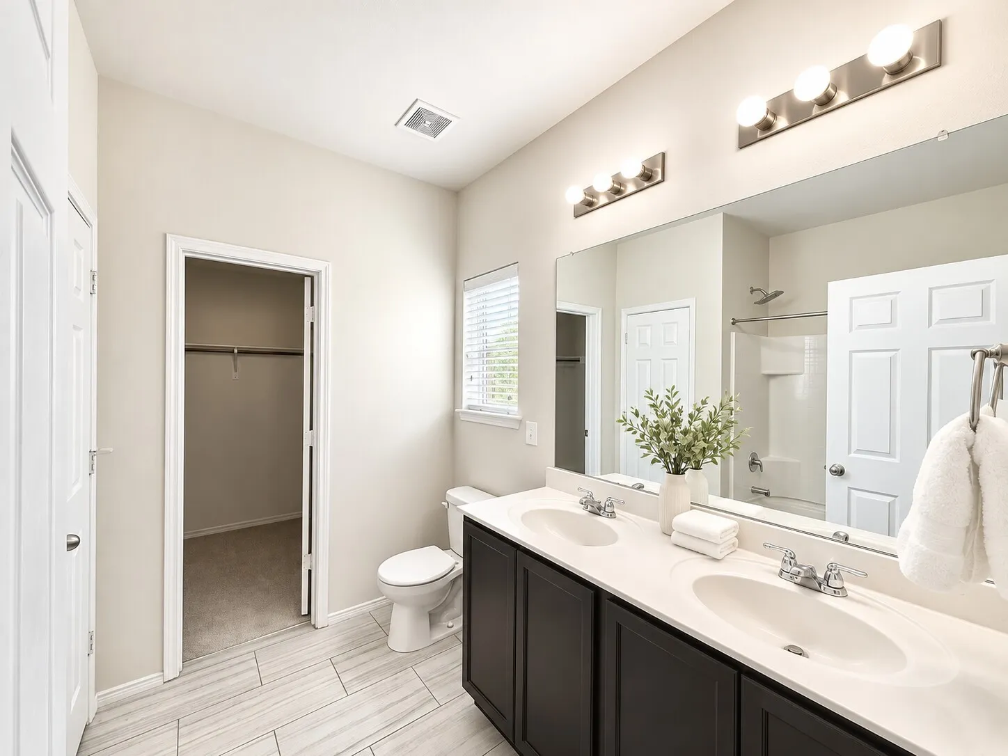 Dual vanity with integrated sinks and dark wood-finish cabinetry