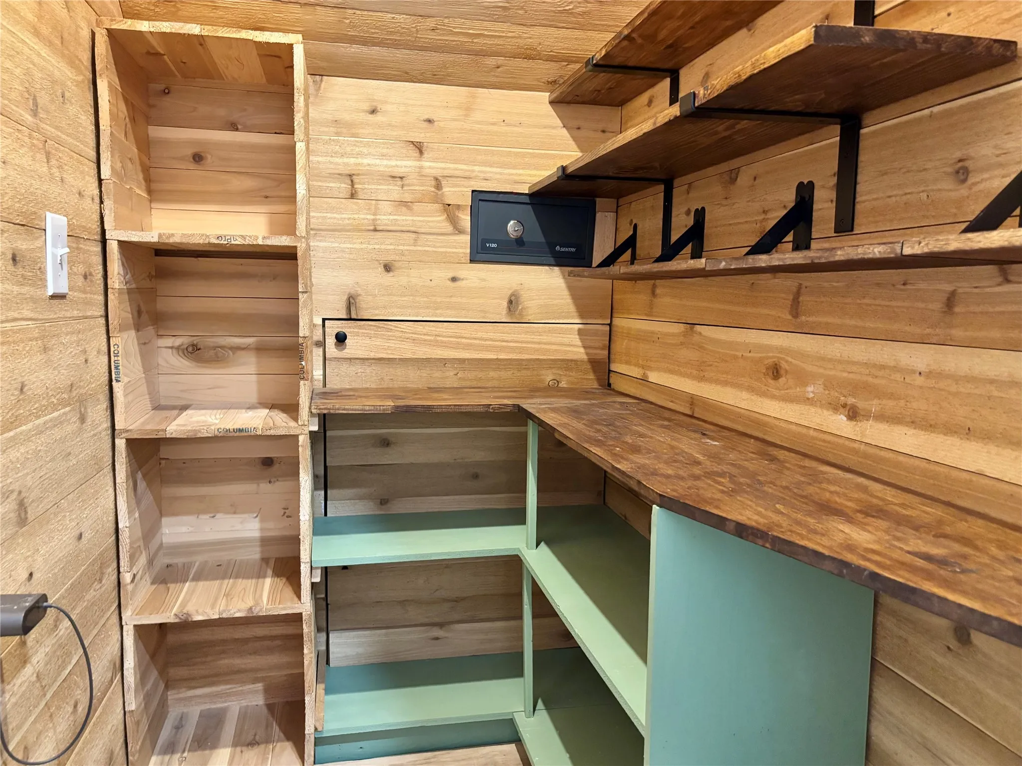 Cedar-paneled room featuring a built-in safe and shelving.