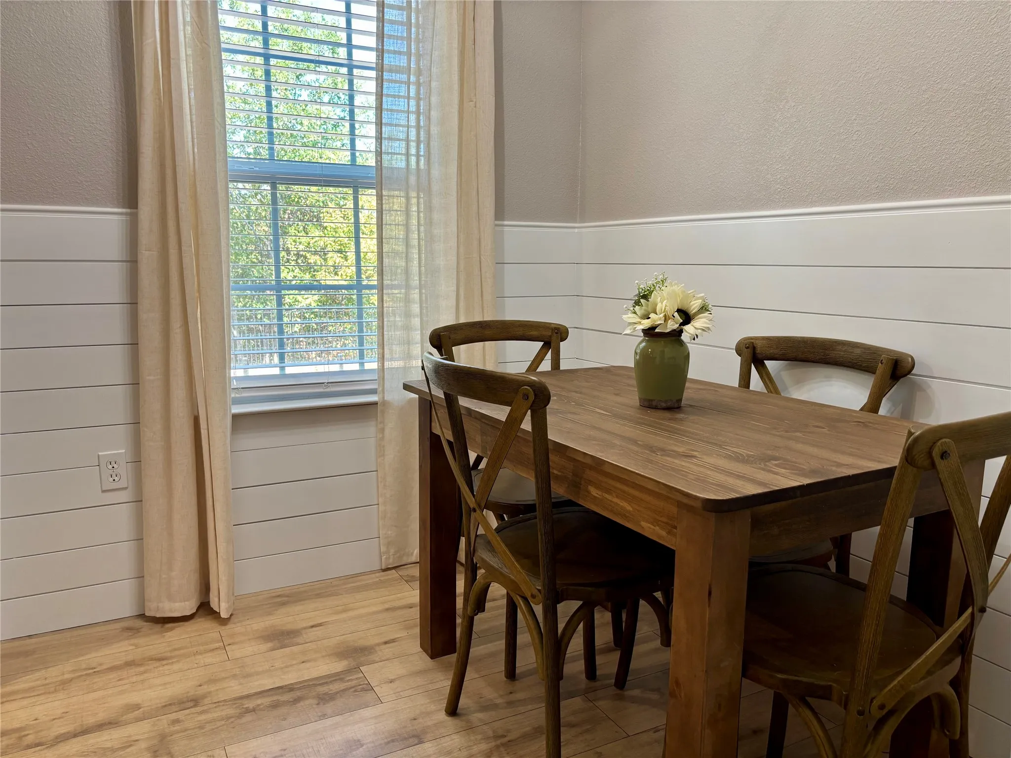 Wood-finish flooring, white shiplap wainscoting with wonderful natural lighting.